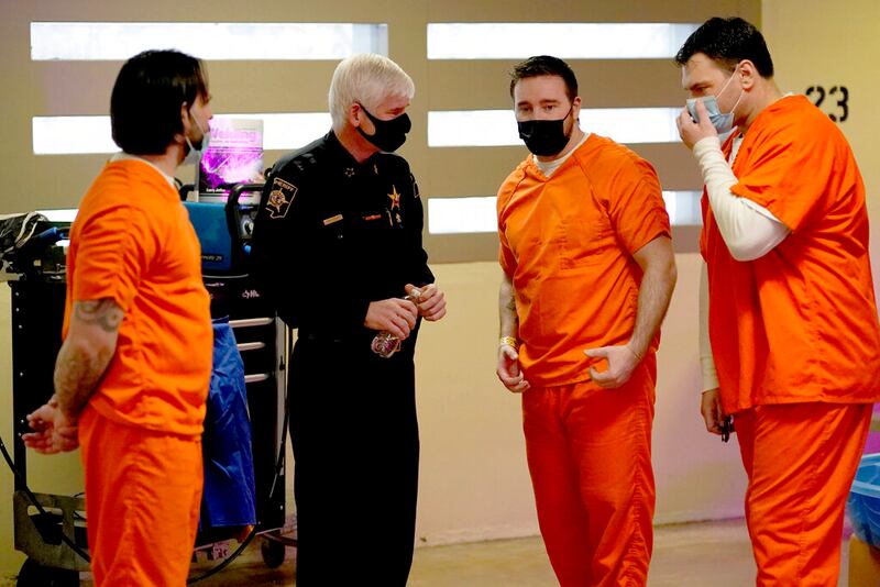 El sheriff James Mendrick (centro) habla con Erik Eck (izq), Jay, (der) y Joe, tres reos que participan en un programa de rehabilitación de pandilleros en una cárcel de Wheaton, Illinois, el 3 de febrero del 2022. (AP Photo/Charles Rex Arbogast)