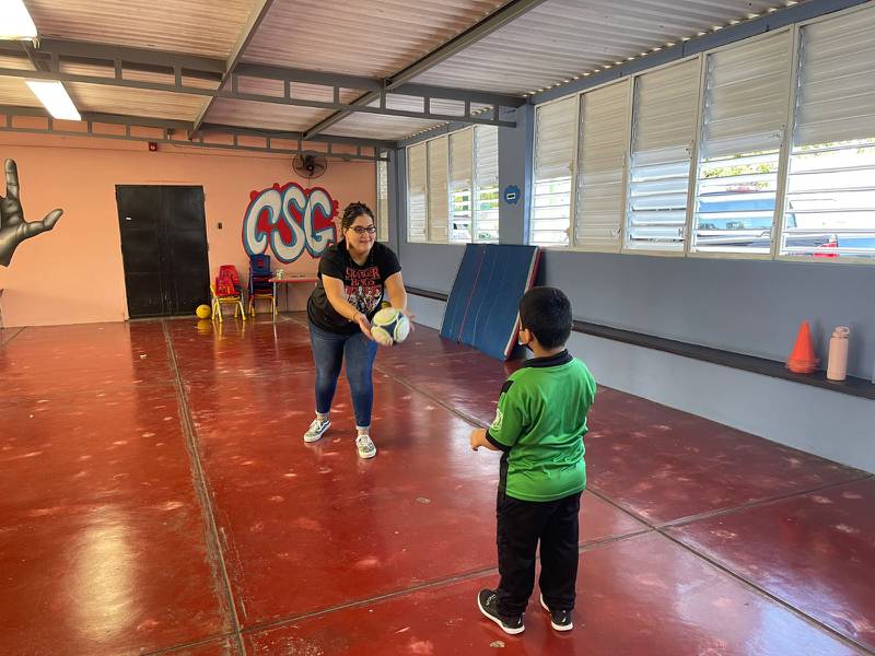 Loraine Cuevas y un estudiante del Colegio San Gabriel juegan con una pelota de fútbol.