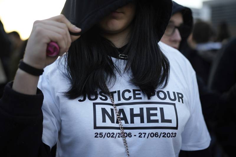 Un manifestante viste una camiseta con la leyenda "Justicia para Nahel" durante una protesta convocada por la madre de Nahel M, un adolescente de 17 años que fue asesinado a tiros por la policía en junio, después de que el agente sospechoso en el caso fue dejado en libertad en lo que se completa la investigación, el domingo 19 de noviembre de 2023, en Nanterre, al oeste de París. (AP Foto/Lewis Joly)