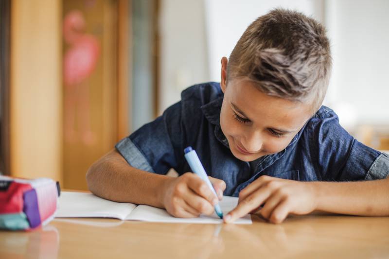 Niño escribiendo a mano