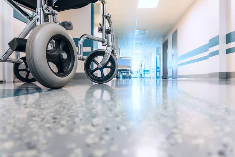 Una silla de ruedas vacía estacionada en el pasillo de un hospital.
