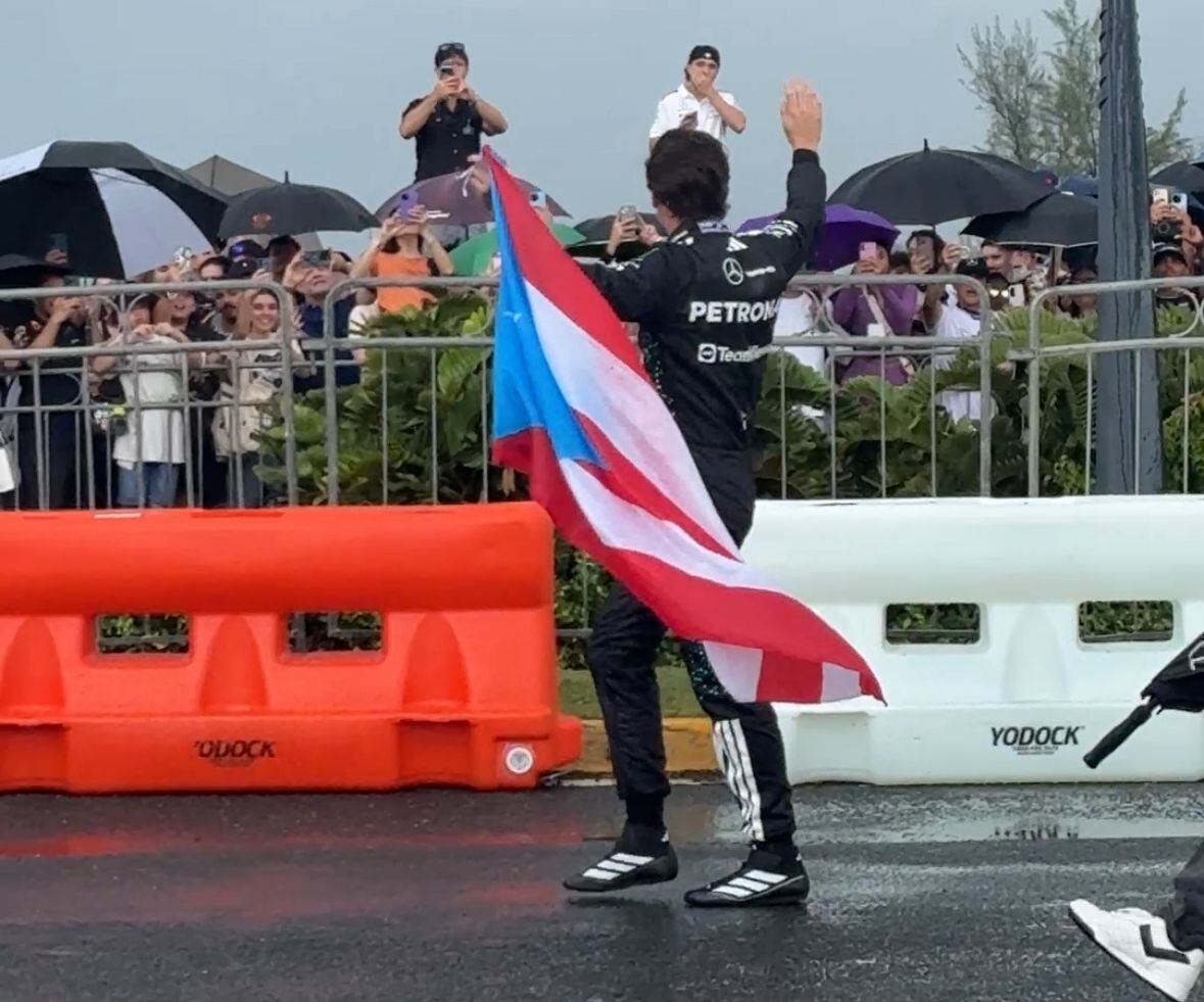 El piloto Esteban Gutiérrez saludando a los fanáticos en el Puente Dos Hermanos, con bandera de Puerto Rico en mano, tras finalizar la primera presentación de un vehículo de motor F1 en Puerto Rico.