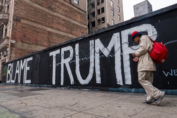 Una persona camina por el centro de Los Ángeles luego del levantamiento del toque de queda nocturno luego de que numerosos negocios fueran asaltados el lunes por la noche mientras continúan las protestas en la ciudad.