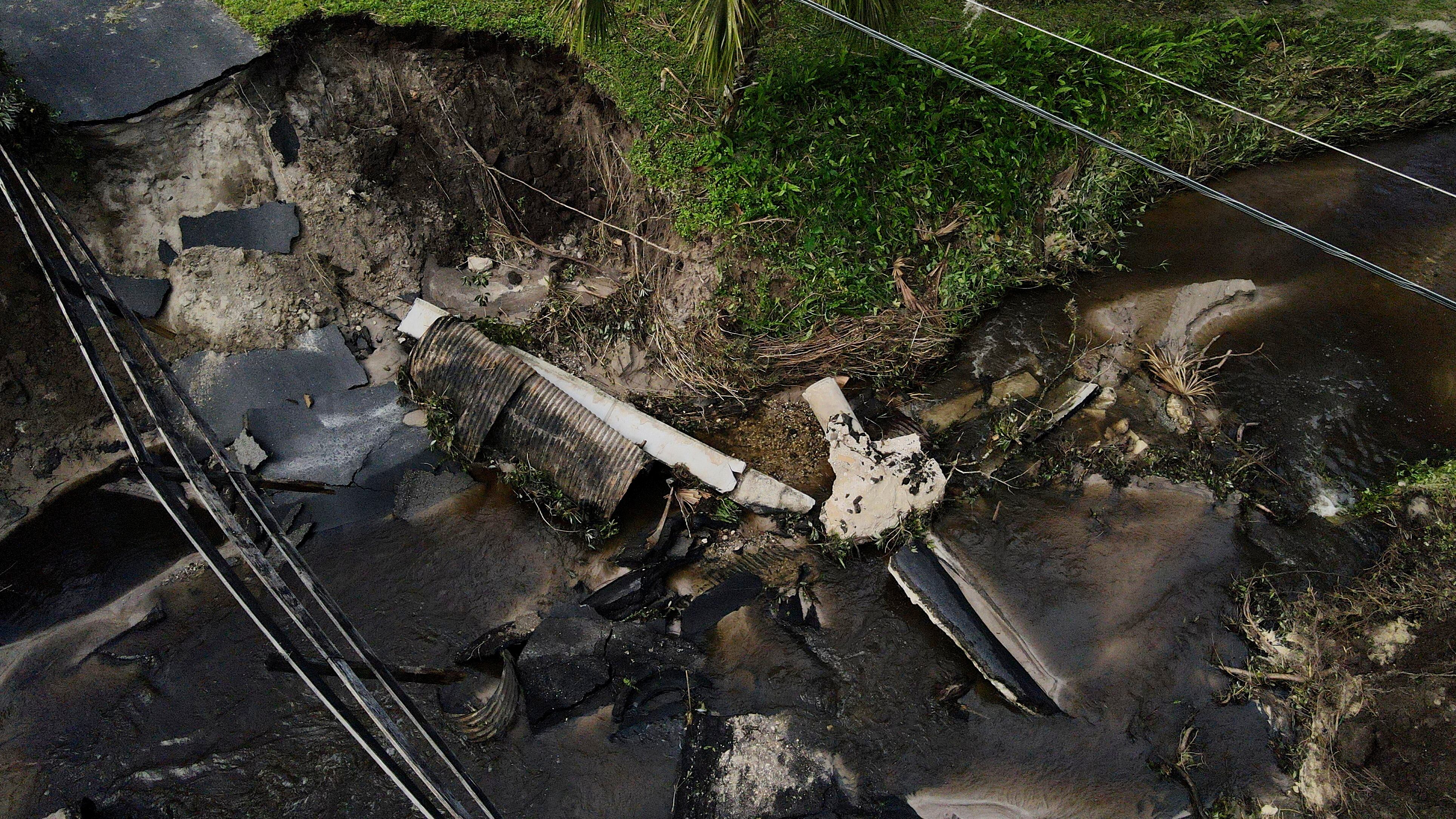 Del Ockey, un canadiense que vive en Florida durante los seis meses más fríos del año, camina cerca de un puente dañado que va hacia su propiedad, en Riverview, Florida, el viernes 11 de octubre de 2024, tras el paso del huracán Milton. (AP Foto/Julio Cortez)