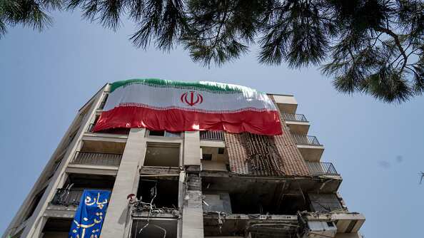 An Iranian flag is draped from a building damaged during a recent attack by Israel in the Gisha neighborhood of Tehran, Iran, on June 25, 2025.