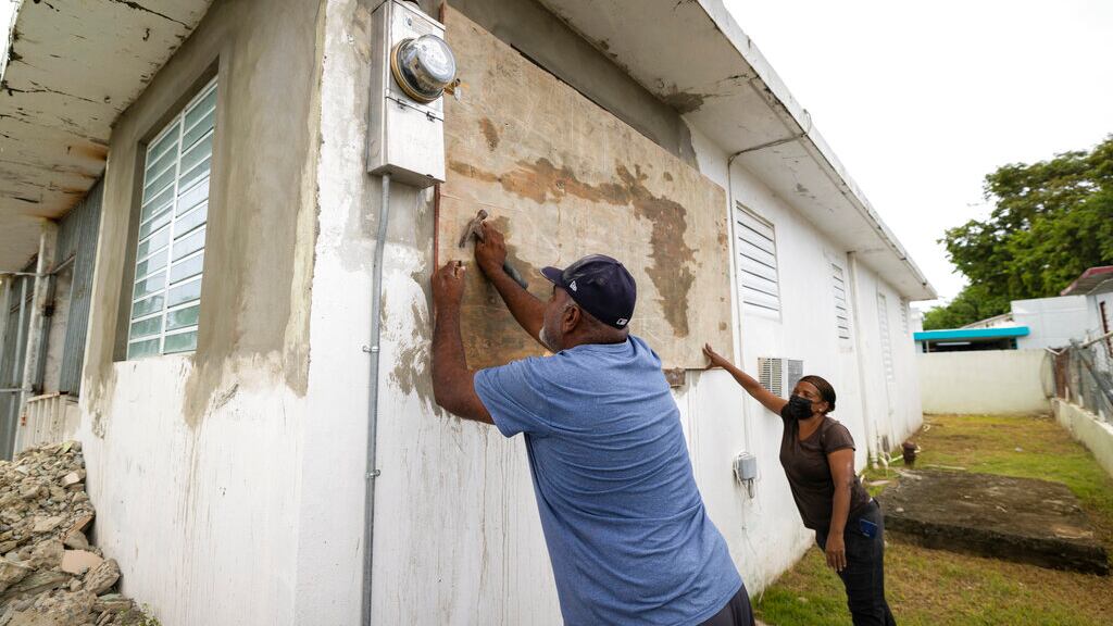 Residentes cubren una ventana de su casa ante la inminente llegada de la tormenta tropical Fiona, en Loiza, Puerto Rico, el sábado 17 de septiembre de 2022.