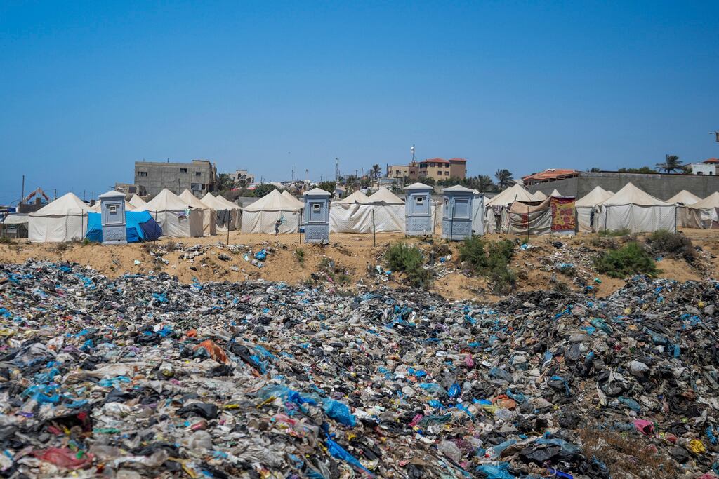 La basura se amontona junto a un campamento improvisado para palestinos desplazados por la ofensiva aérea y terrestre de Israel en el campo de refugiados de Nuseirat, Gaza.