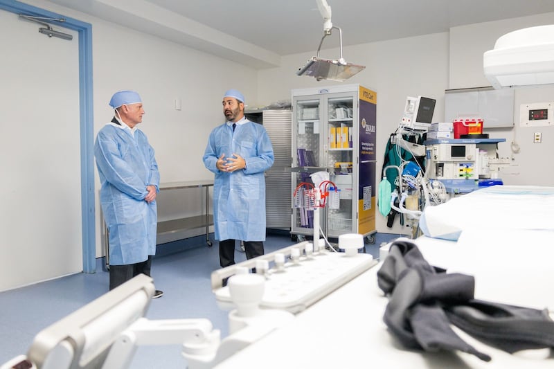 Congresista y doctor vestidos con batas quirúrgicas en sala híbrida del Professional Hospital Guaynabo.