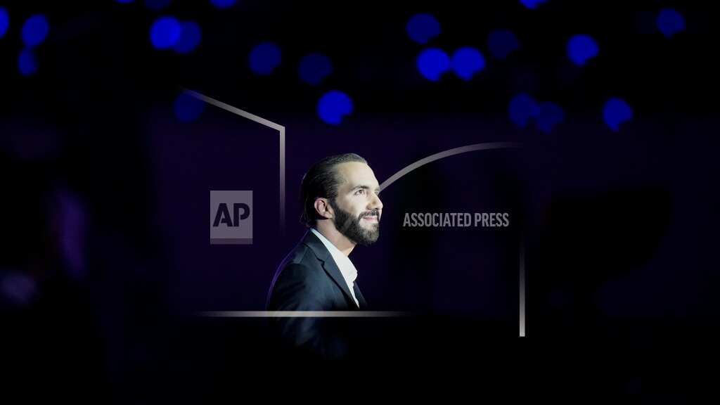 El presidente salvadoreño Nayib Bukele sonríe al ser iluminado en la ceremonia de apertura de los Juegos Centroamericanos y del Caribe, en el recientemente remodelado estadio Jorge "El Mágico" Gonzalez, el 23 de junio de 2023, en San Salvador, El Salvador. (AP Foto/Arnulfo Franco, archivo)