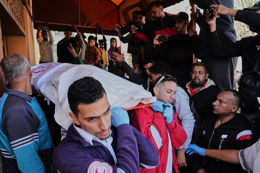 Dolientes cargan los cuerpos de ocho miembros de la Media Luna Roja, recuperados en Rafah una semana después de un ataque israelí, mientras son trasladados para su entierro desde un hospital en Deir al-Balah, Franja de Gaza. (Foto AP/Abdel Kareem Hana)