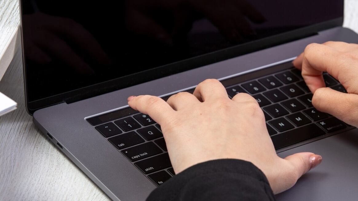 Una chica de vista frontal usando una computadora portátil frente a la mesa usando una actividad comercial