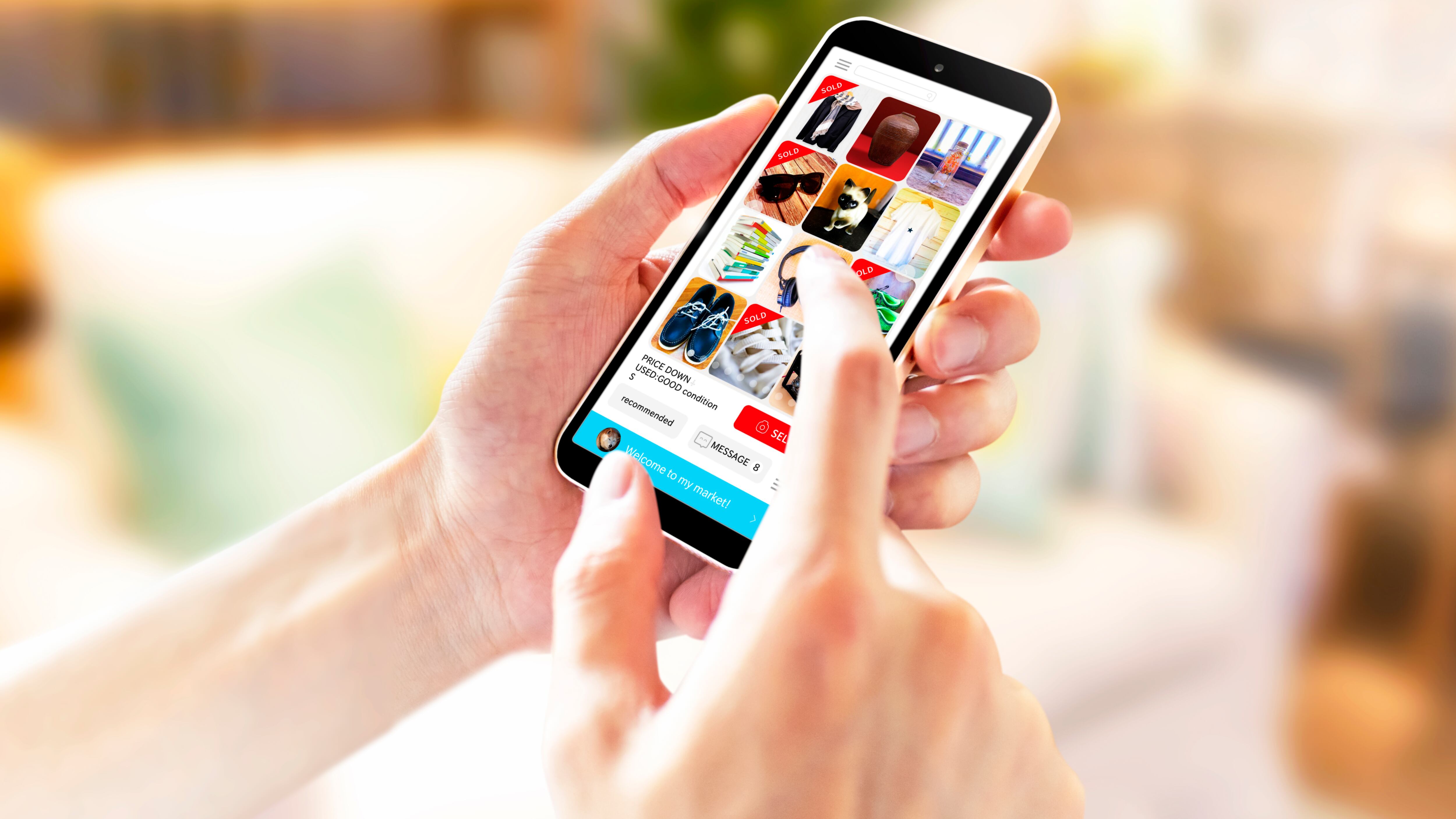 Una persona sostiene un teléfono celular, desde donde compra diversos artículos.