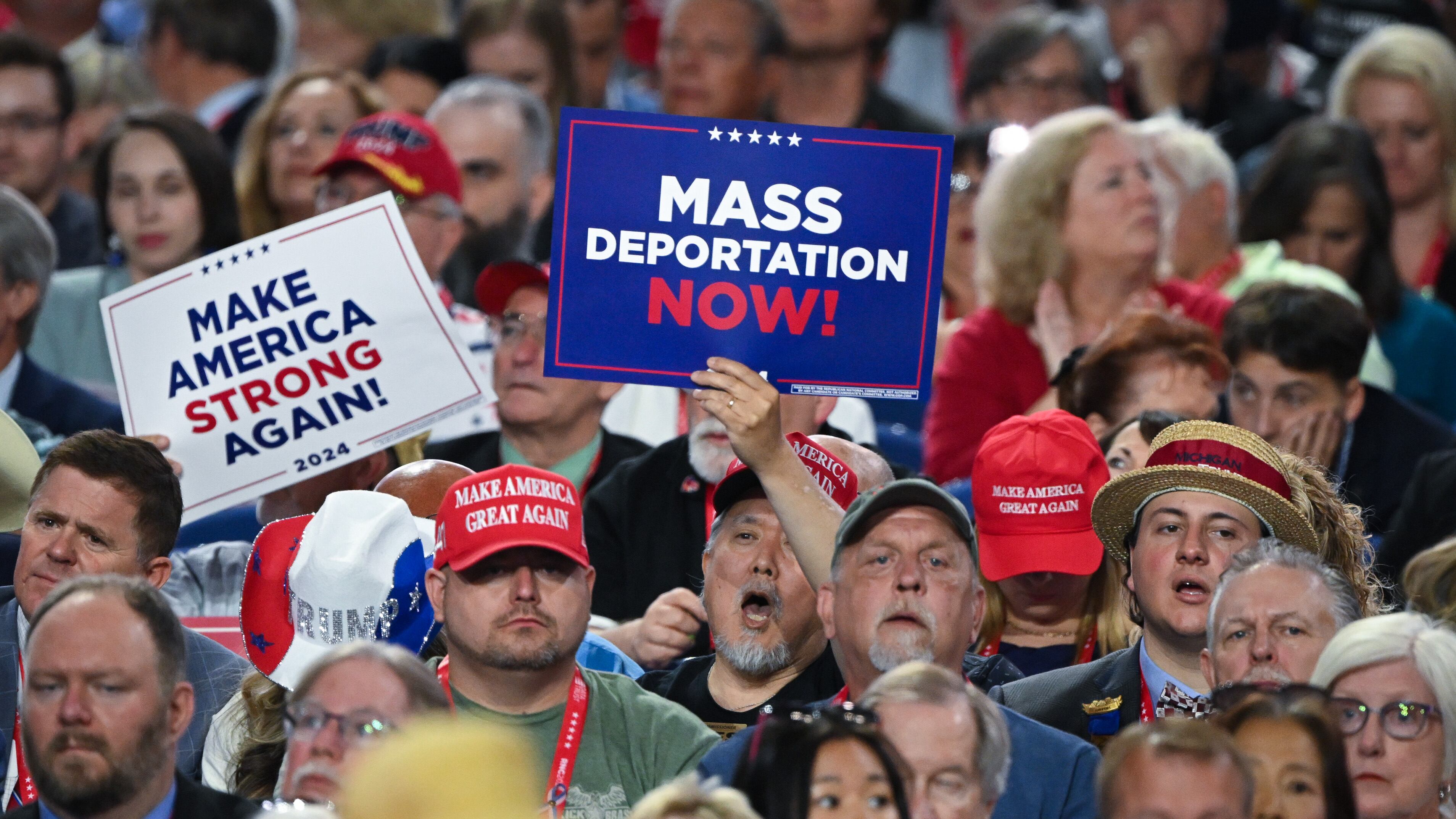 Una persona sostiene un cartel que dice "Deportación masiva ahora" en la Convención Nacional Republicana en julio de 2024 en Milwaukee, Wisconsin.