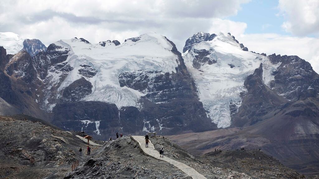 ARCHIVO - Turistas caminan frente al glaciar Tuco en el Parque Nacional de Huascarán durante un tour llamado "Ruta por el cambio climático" en Huaraz, Perú, el 12 de agosto de 2016. El país sudamericano ha perdido más de la mitad de la superficie de sus glaciares en las últimas seis décadas y 175 glaciares se extinguieron entre 2016 y 2020 como consecuencia del cambio climático, según anunciaron el miércoles 22 de noviembre de 2023 científicos de la agencia estatal de Perú que estudia los glaciares. (AP Foto/Martín Mejía, Archivo)