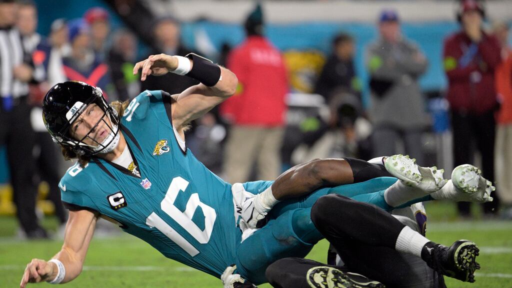 Trevor Lawrence (16), quarterback de los Jaguars de Jacksonville, es derribado por Justin Madubuike, tackle defensivo de los Ravens de Baltimore, después de un pase lanzado por Lawrence durante la segunda mitad del juego de la NFL, el domingo 17 de diciembre de 2023, en Jacksonville, Florida. (AP Foto/Phelan M. Ebenhack)