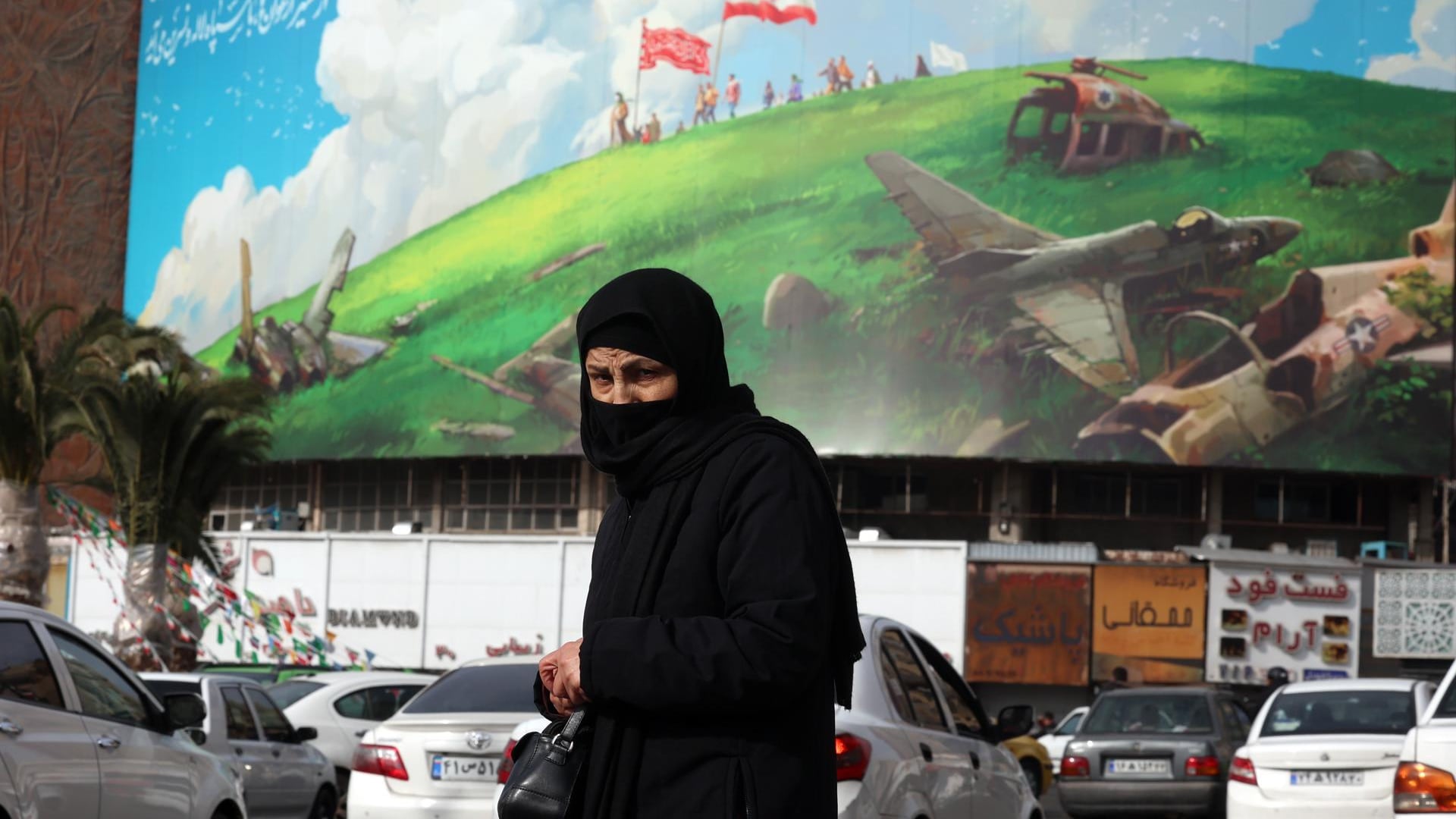 Una mujer iraní pasa junto a un cartel antiestadounidense en la plaza Valiasr en Teherán, Irán, el 14 de febrero de 2026. EFE/EPA/ABEDIN TAHERKENAREH