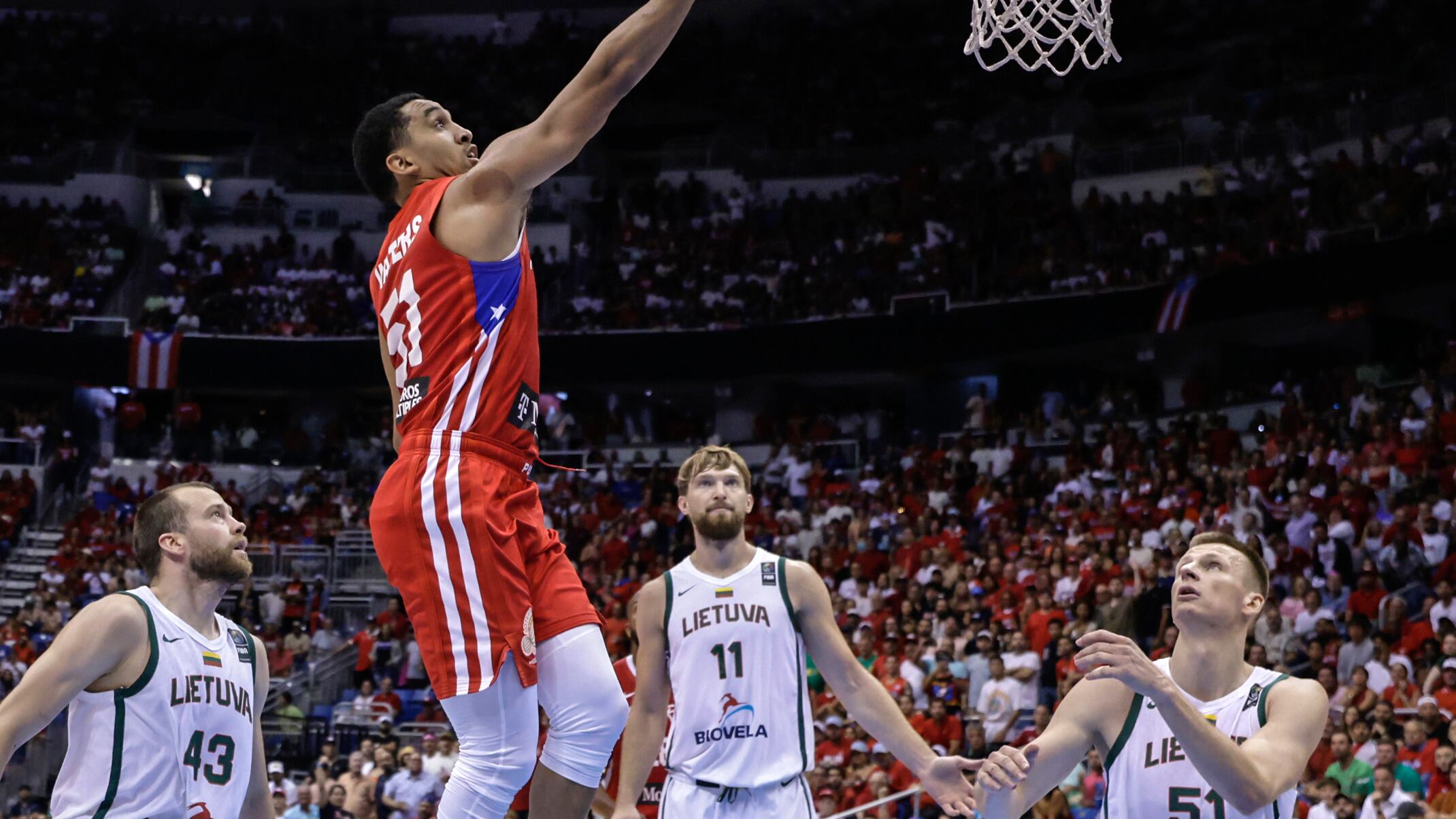 Tremont Waters, de Puerto Rico tira hacia el aro mientras Arnas Butkevicius (derecha), Domantas Sabonis (segundo desde la derecha), y Lukas Lekavicius, observan en el juego final del Torneo Clasificatorio Olímpico de FIBA en San Juan, Puerto Rico, el domingo 7 de julio de 2024. (AP Foto/Alejandro Granadillo)