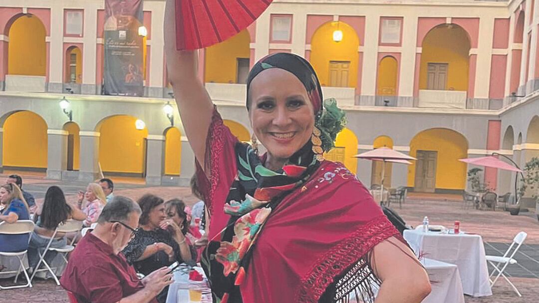 Elsa Victoria Lavergne Beauchamp, sobreviviente de cáncer de seno, posa y sonríe con un vestido flamenco.