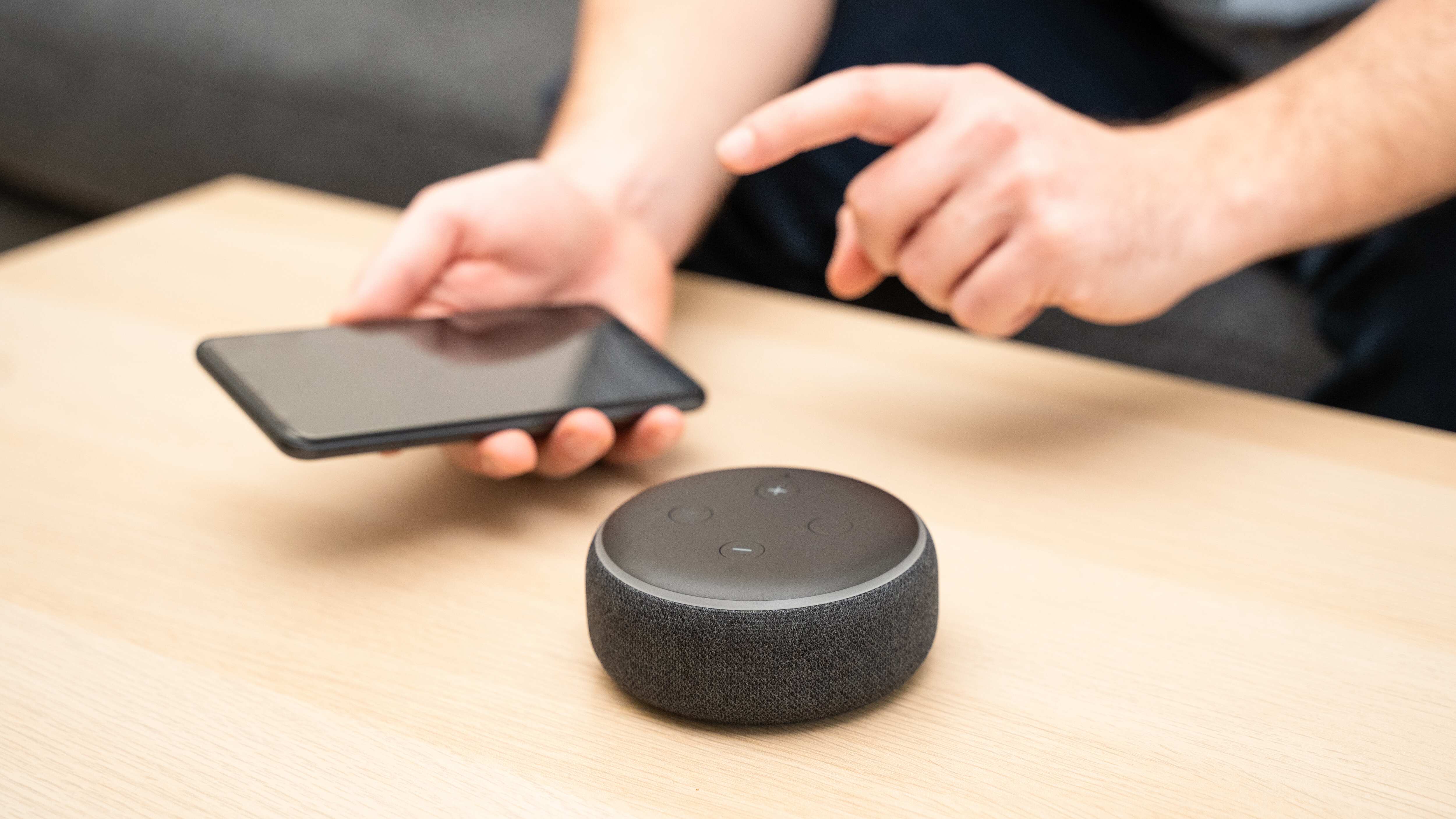 Un hombre usa un asistente virtual y un altavoz inteligente.
