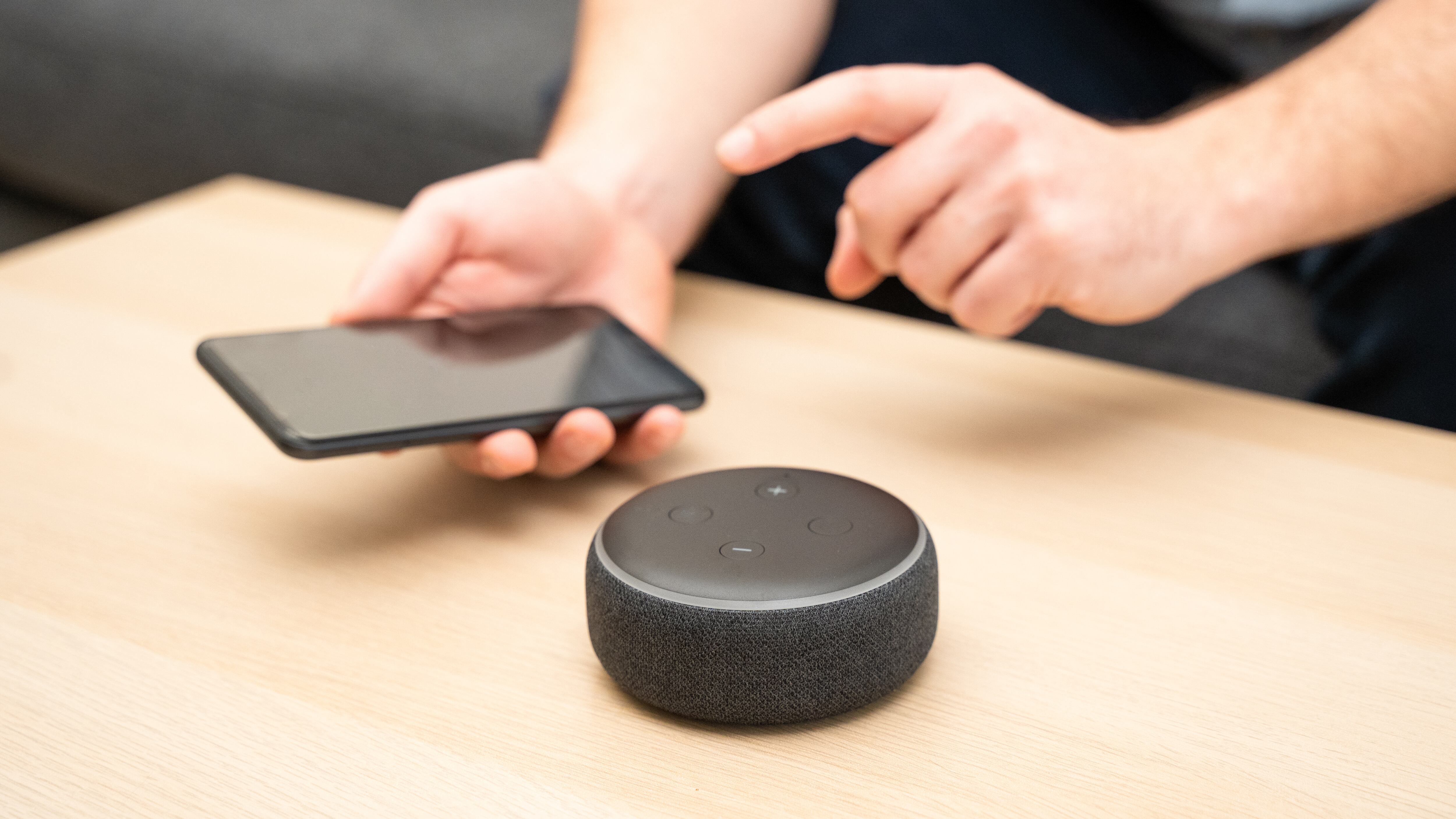 Un hombre usa un asistente virtual y un altavoz inteligente.