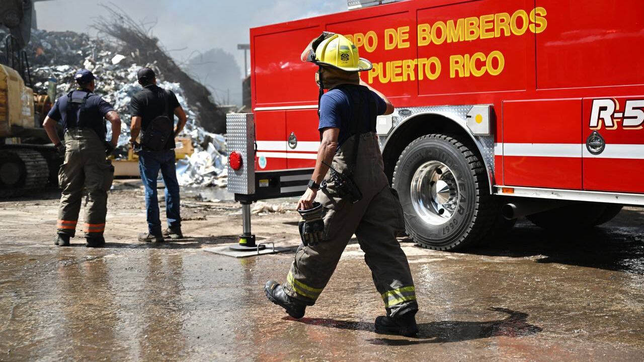 Miembros del Cuerpo de Bomberos trabajan para extinguir fuego en planta de reciclaje en Gurabo.