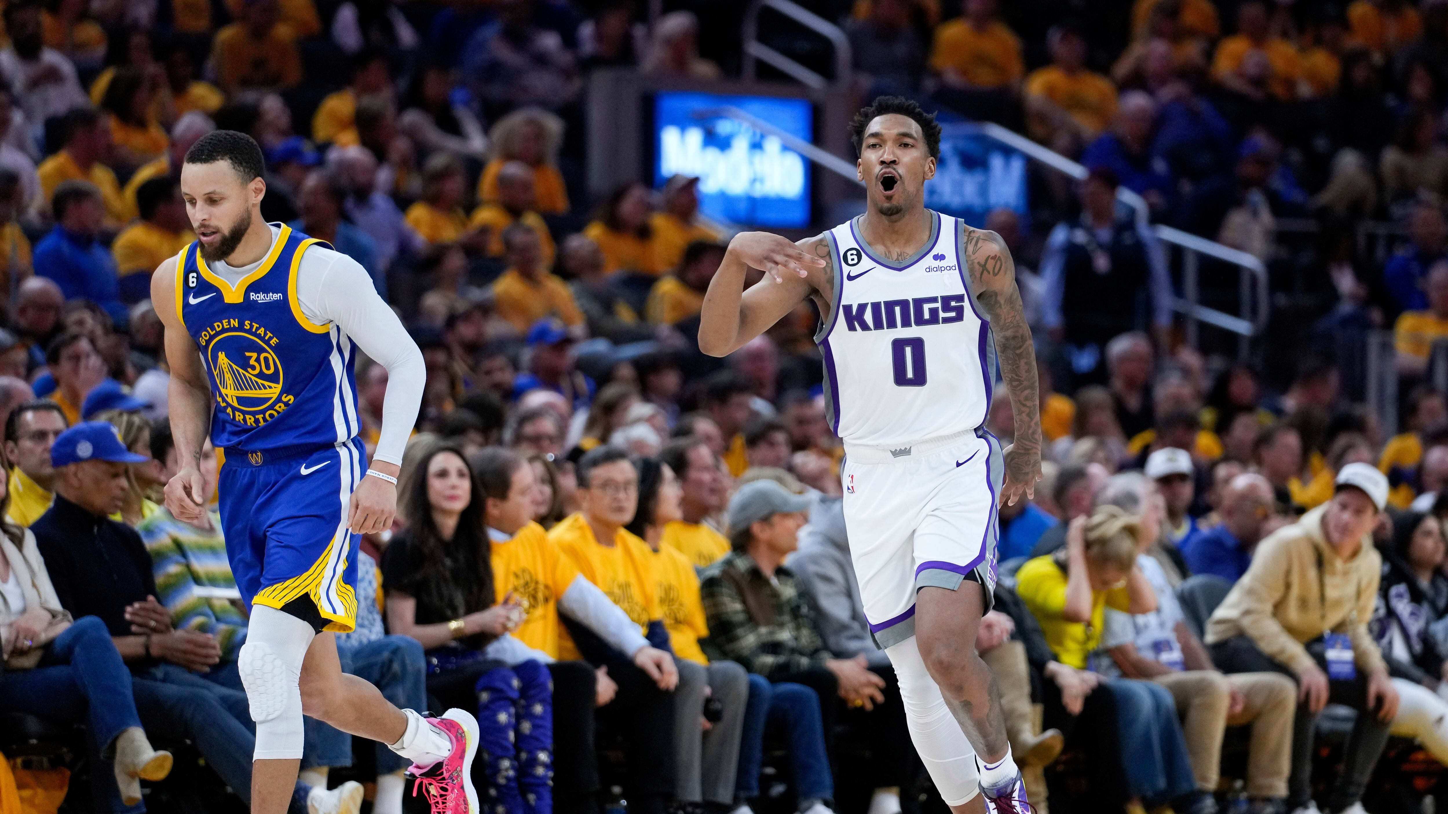 Malik Monk, base de los Kings de Sacramento, festeja luego de atinar un triple junto a Stephen Curry, base de los Warriors de Golden State, en el encuentro de playoffs disputado el viernes 28 de abril de 2023.
