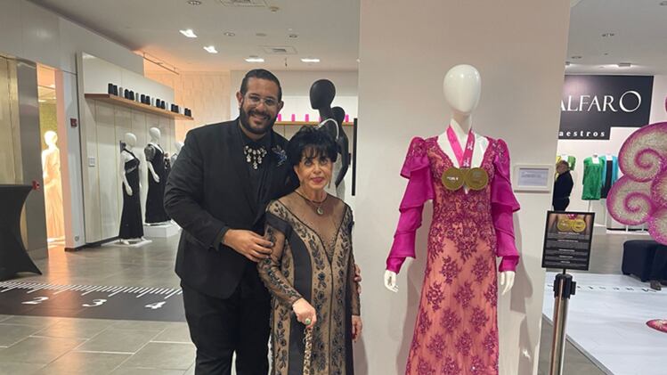 Joseph Daponte y la diseñadora Carlota Alfaro junto al vestido rosa que será subastado.