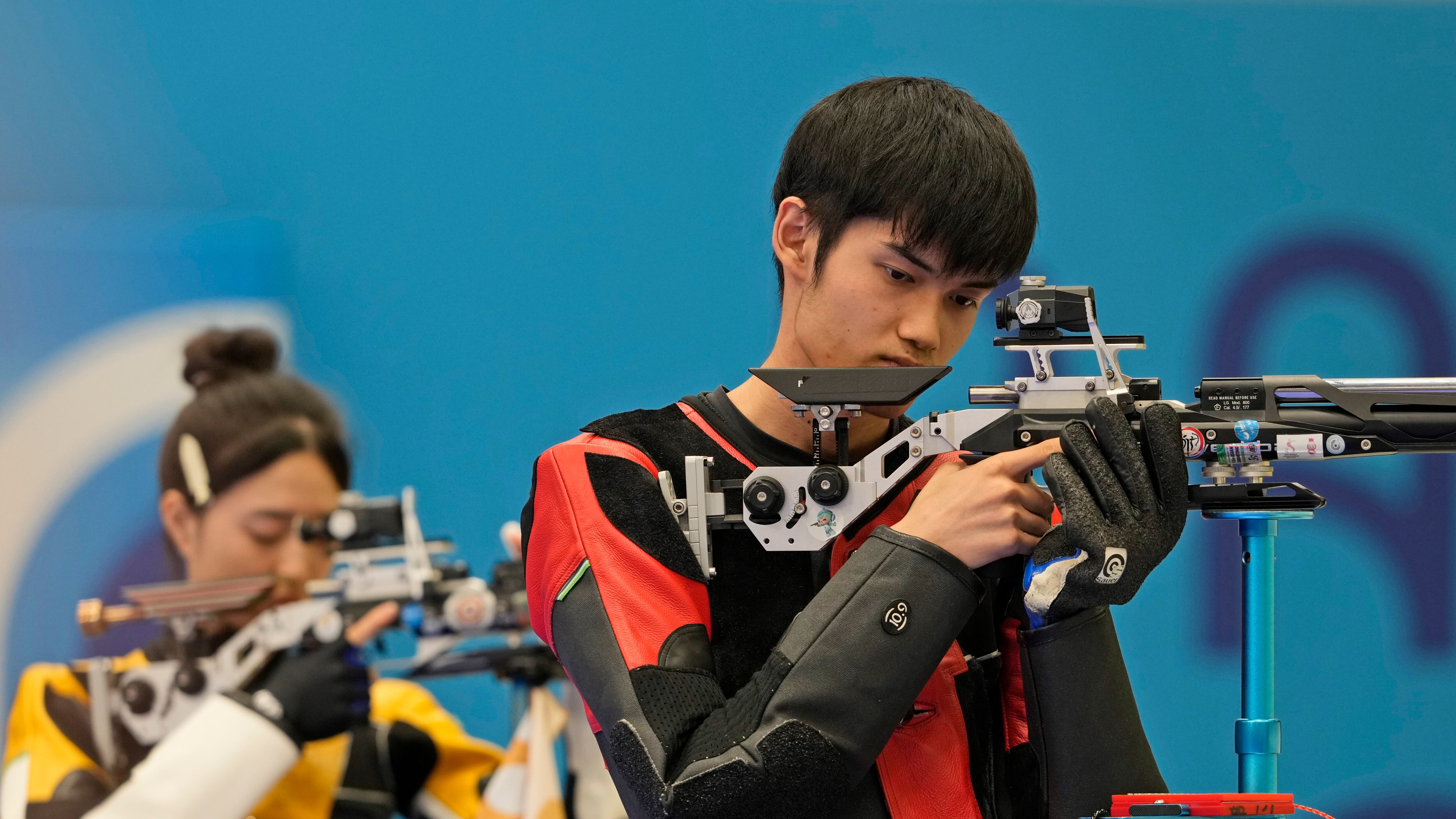Los chinos Sheng Lihao (derecha) y Huang Yuting compiten por la medalla de oro de la prueba de equipos mixtos con carabina comprimida desde 10 metros en los Juegos Olímpicos, el sábado 27 de julio de 2024, en Chateauroux, Francia. (AP Foto/Manish Swarup)