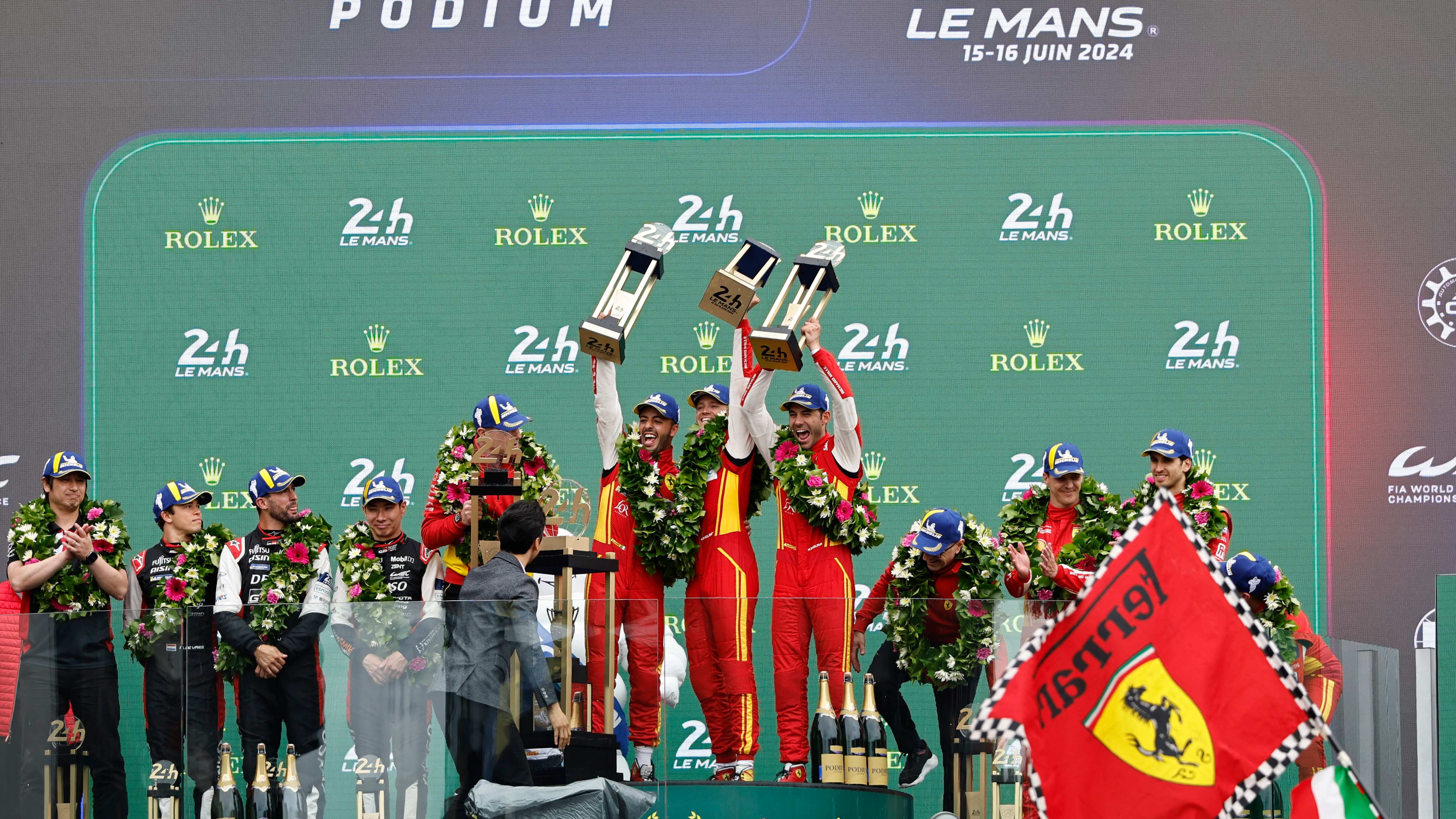 El equipo Ferrari 499P Hybrid Hypercar WEC, el piloto español Miguel Molina, el piloto italiano Antonio Fuoco y el piloto danés Nicklas Nielsen celebran en el podio después de ganar la carrera de autos deportivos Las 24 Horas de Le Mans el domingo 16 de junio de 2024 en Le Mans, Francia. (Foto AP/Jeremías González)