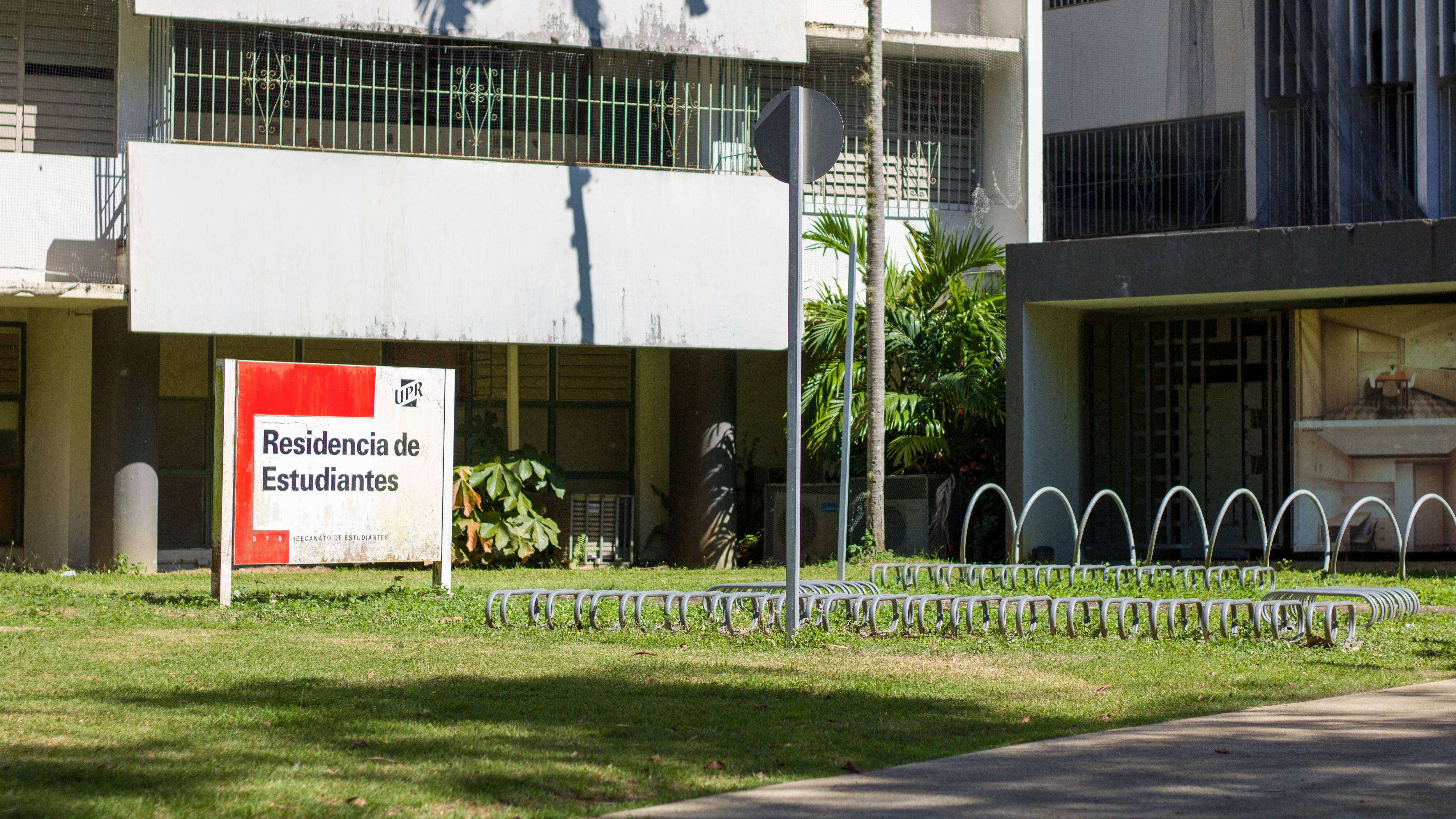 Resicampus detrás de un cartel que la identifica como "Residencias estudiantiles" con el sello de la UPR.