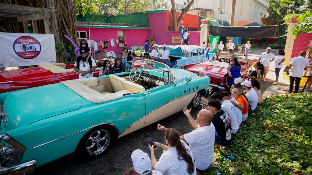 Propietarios y conductores de automóviles y motocicletas clásicos y antiguos se reúnen antes del inicio del Rally de Autos Antiguos de La Habana, en La Habana, Cuba, el domingo 3 de diciembre de 2023. El rally celebra el 125to aniversario de la llegada del primer automóvil a la isla. (Foto AP/Ismael Francisco)
