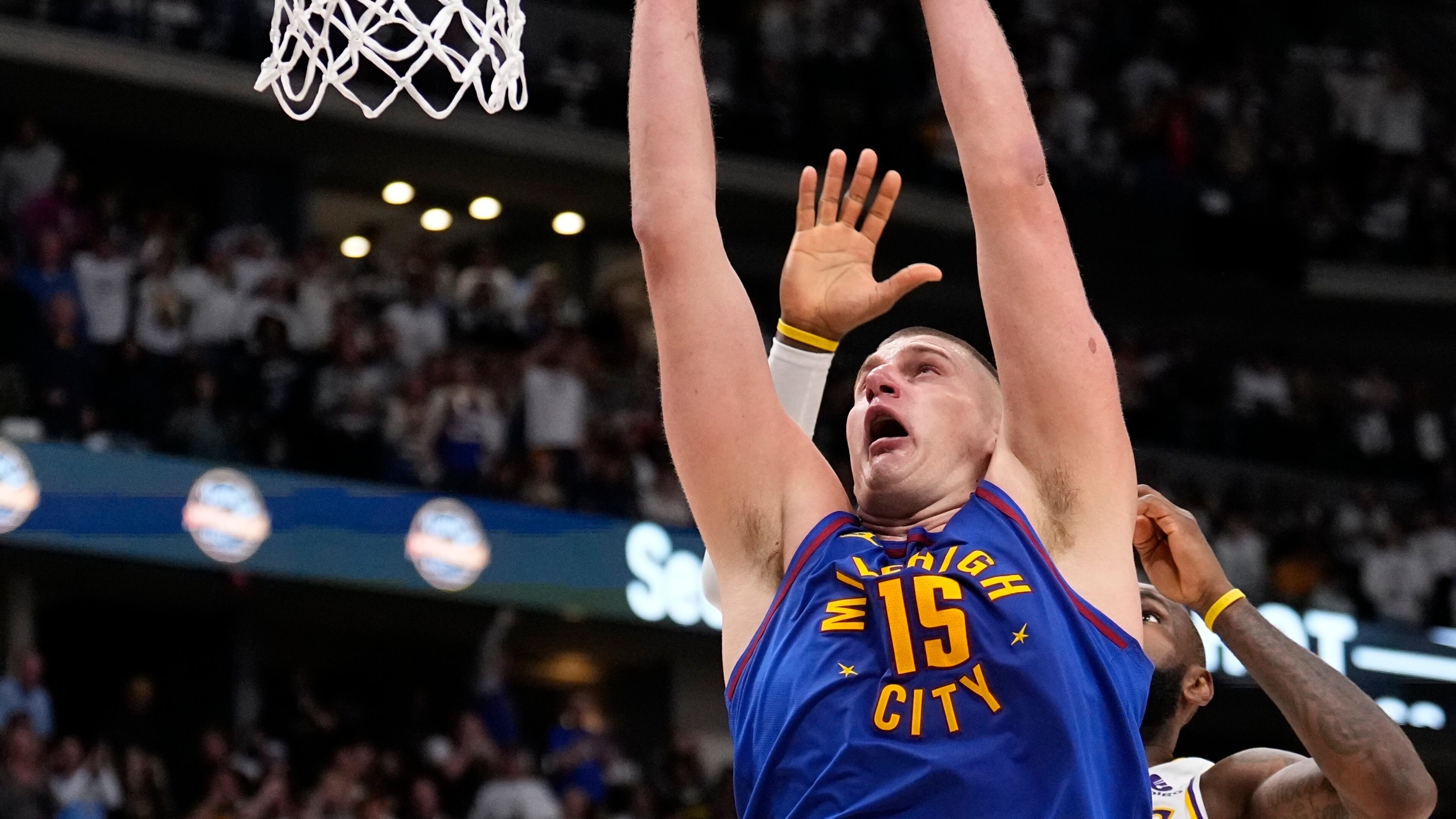 El serbio Nikola Jokic, de los Nuggets de Denver, realiza una clavada frente a LeBron James, de los Lakers de Los Ángeles, el sábado 20 de abril de 2024 (AP Foto/Jack Dempsey)