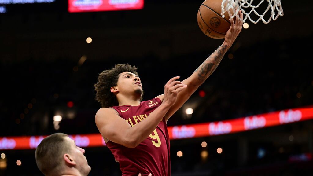 Craig Porter, de los Cavaliers de Cleveland, se alista a encestar contra los Nuggets de Denver, ante la mirada de Nikola Jokic, en la segunda mitad del juego de baloncesto de la NBA, el domingo 19 de noviembre de 2023, en Cleveland. (AP Foto/David Dermer)
