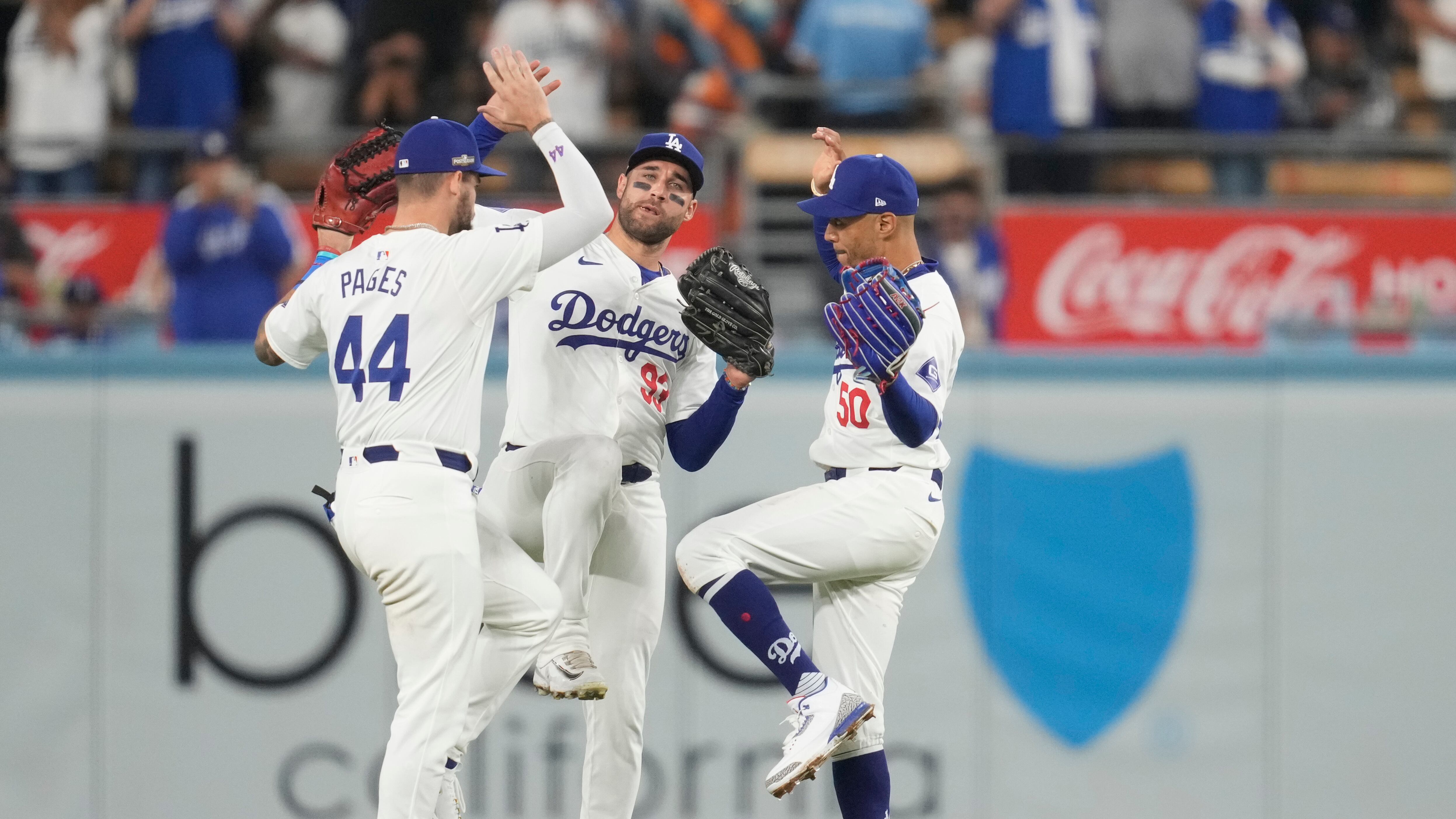 Los jardineros de los Dodgers de Los Ángeles, Andy Pages, Kevin Kiermaier y Mookie Betts celebran su victoria contra los Mets de Nueva York en el primer juego de la Serie de Campeonato de la Liga Nacional de béisbol, el domingo 13 de octubre de 2024, en Los Ángeles. (Foto AP/Ashley Landis)