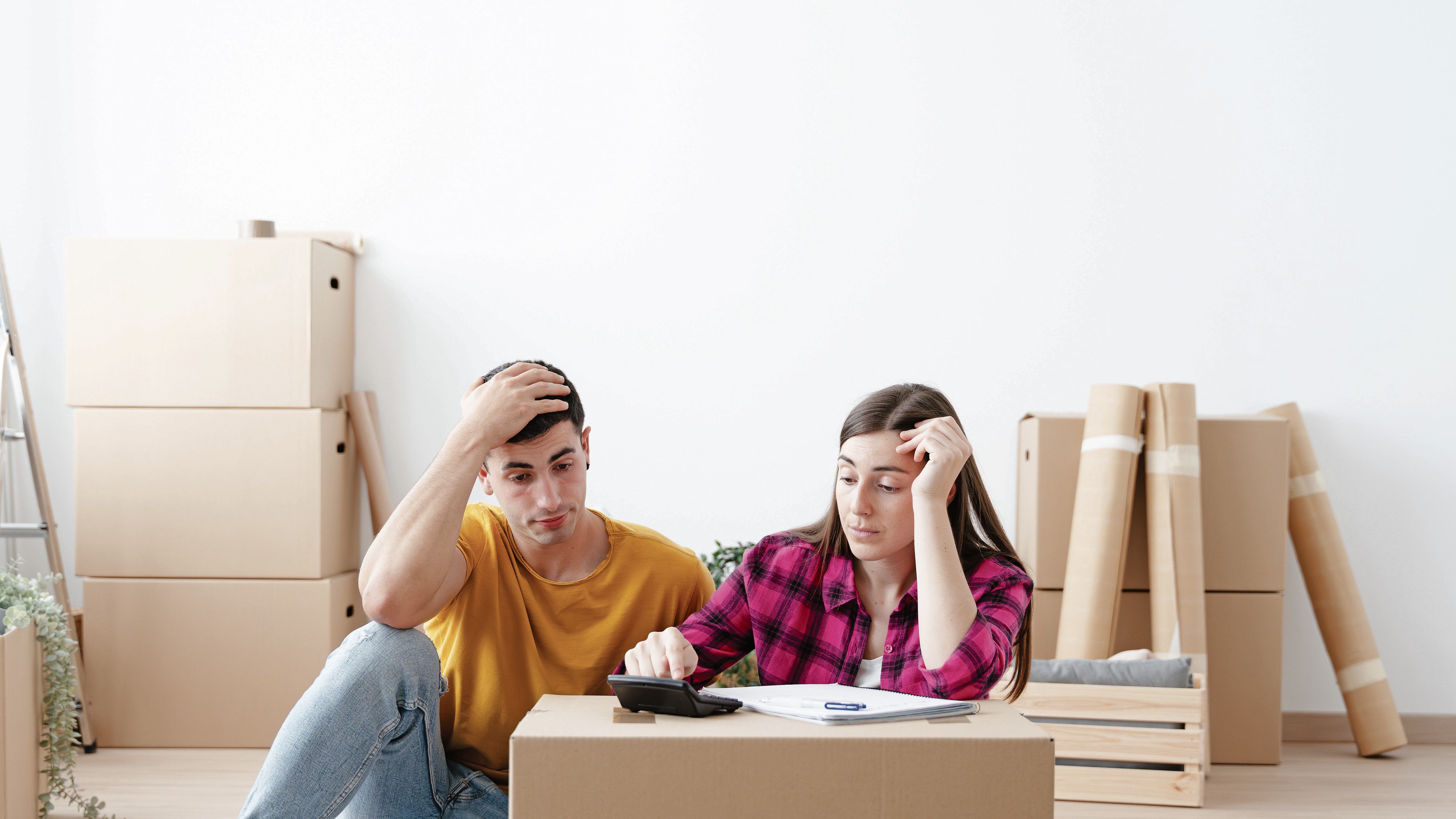 Domestic or home economy concept with copy space. Young worried couple calculating expenses or mortgage in their new house.