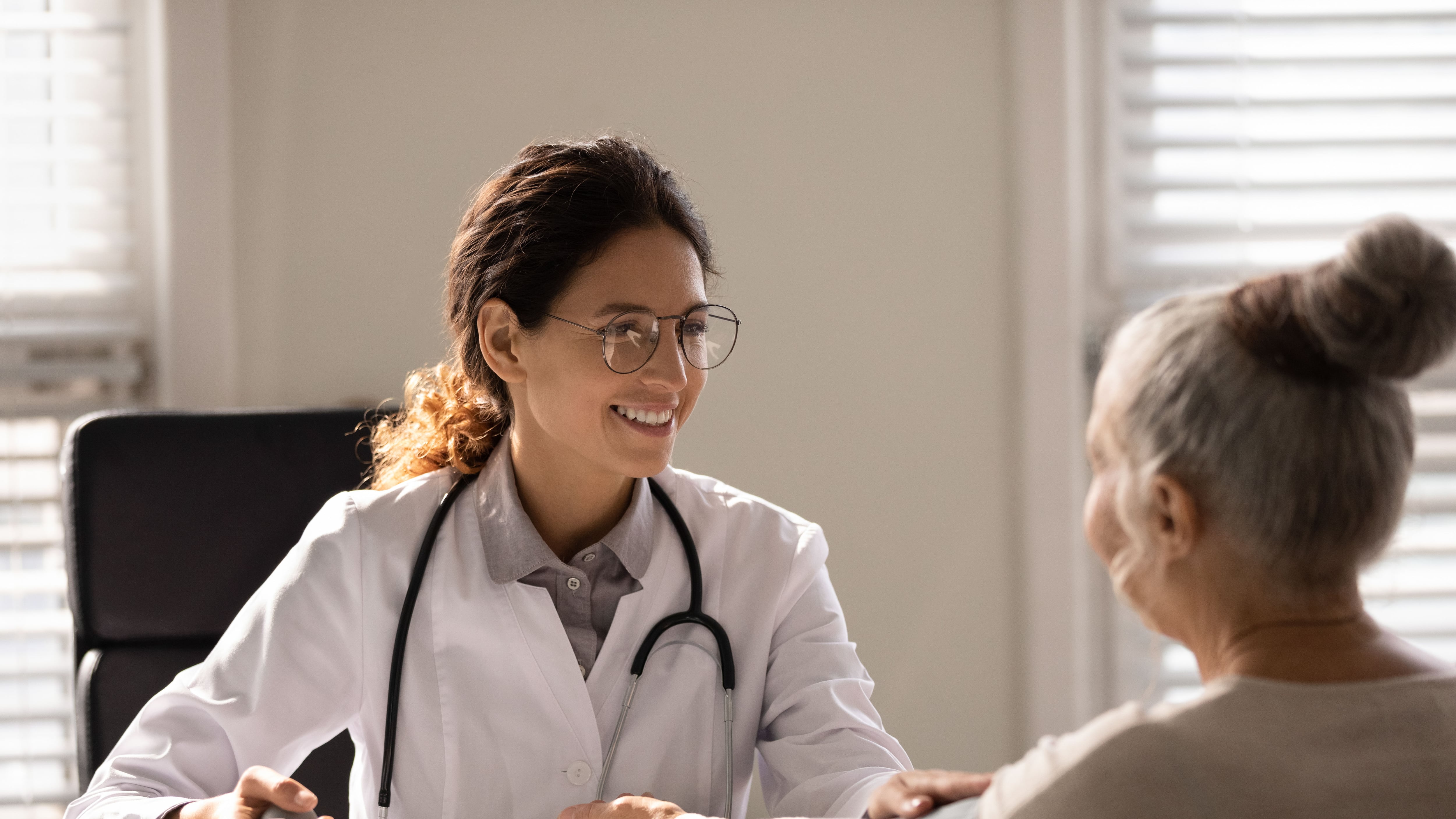 Control de la presión arterial. Una doctora mide la presión arterial de una paciente mayor.