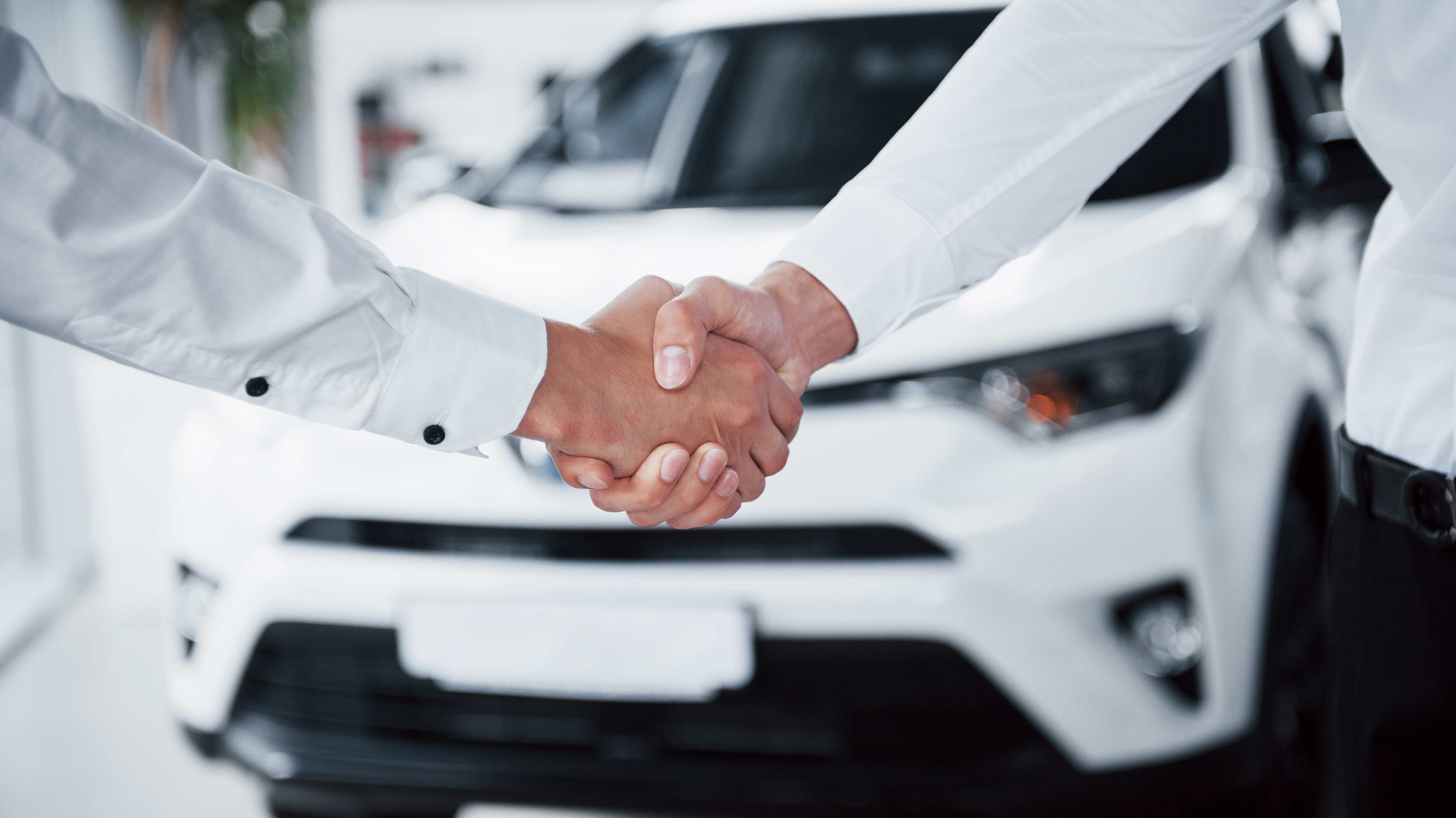 Cierre de gerente de ventas en traje negro vendiendo el auto al cliente