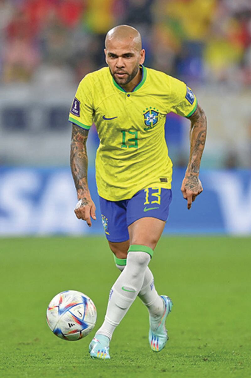 Dani Alves mira enfocado el balón antes de patearlo.