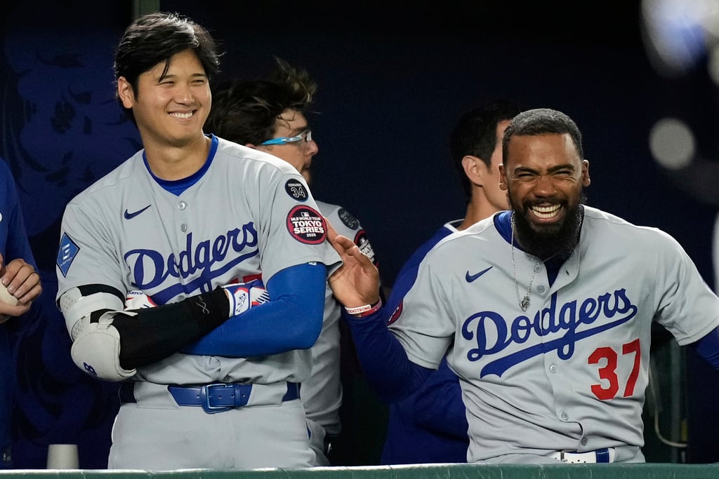 Shohei Ohtani (izquierda) y Teoscar Hernández de los Dodgers de Los Ángeles bromean durante el octavo inning del juego contra los Cachorros de Chicago, el martes 18 de marzo de 2025, en Tokio. (AP Foto/Hiro Komae)