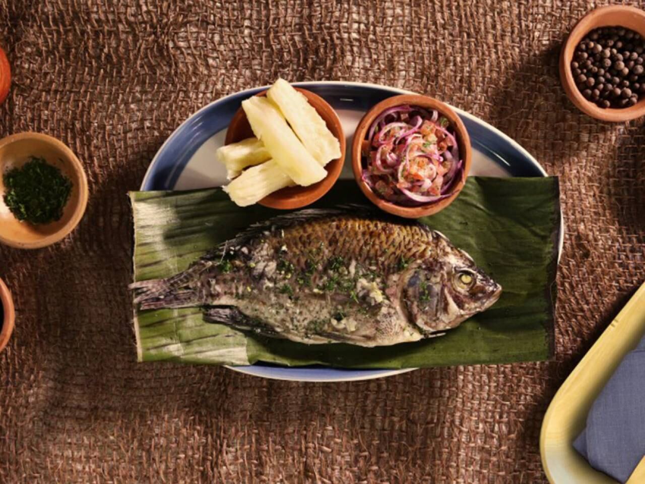 Pescado envuelto en hojas de bijao, acompañado de yuca o plátano asado.
