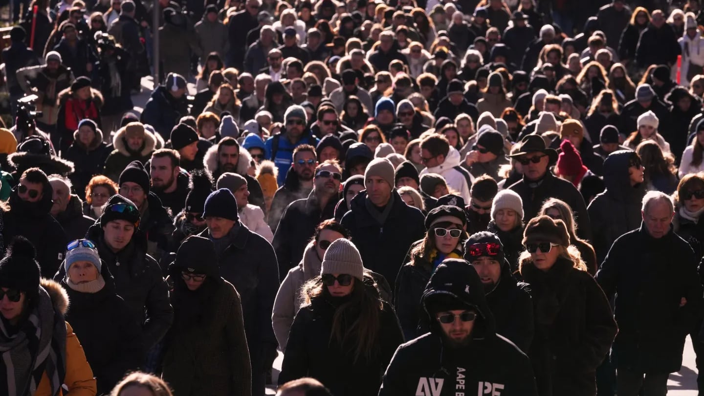 Personas caminan durante una procesión en Crans-Montana, Suiza, el domingo 4 de enero de 2026