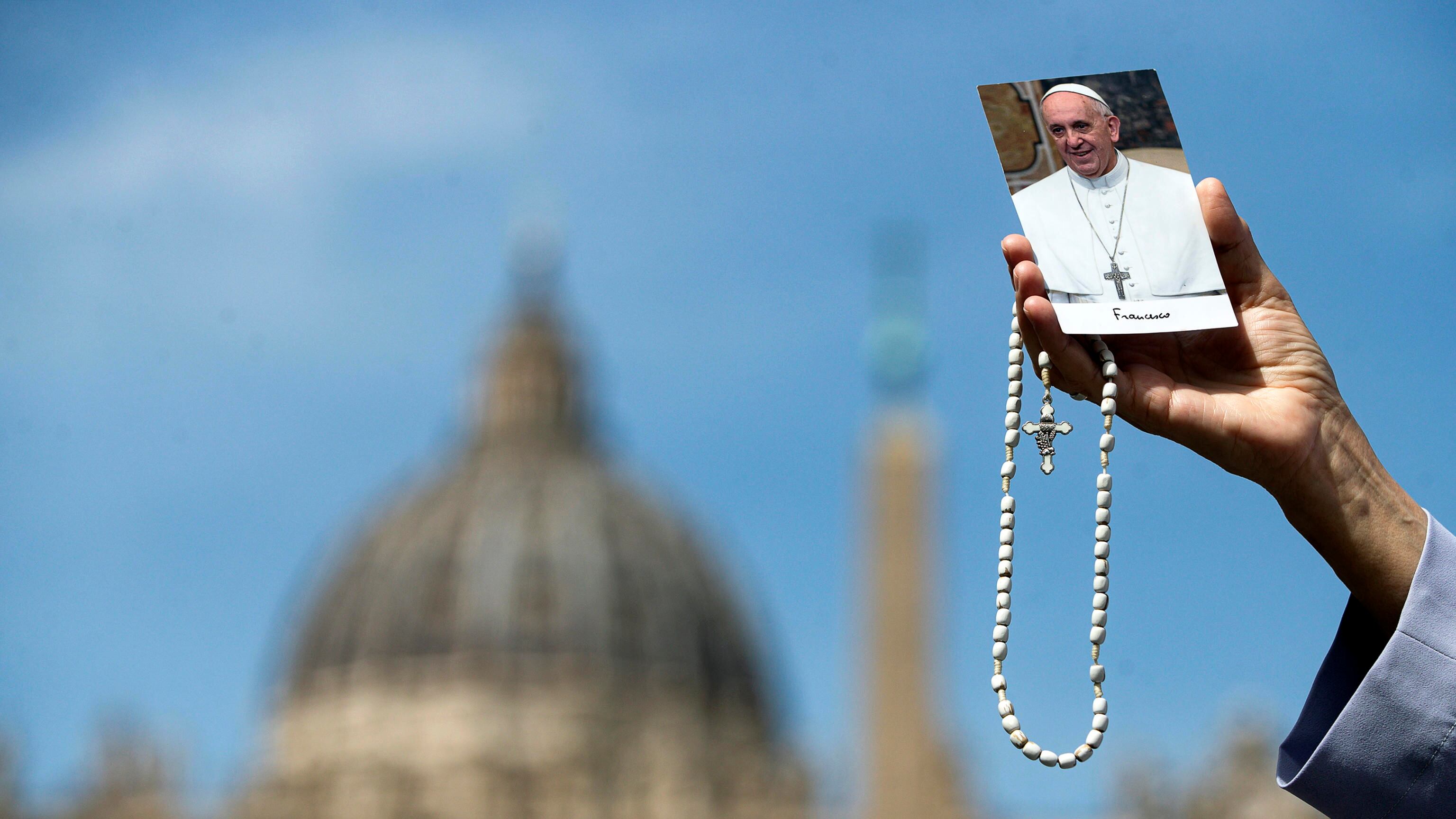 Una monja muestra una foto del papa Francisco durante su rezo este lunes en la Plaza de San Pedro en el Vaticano.