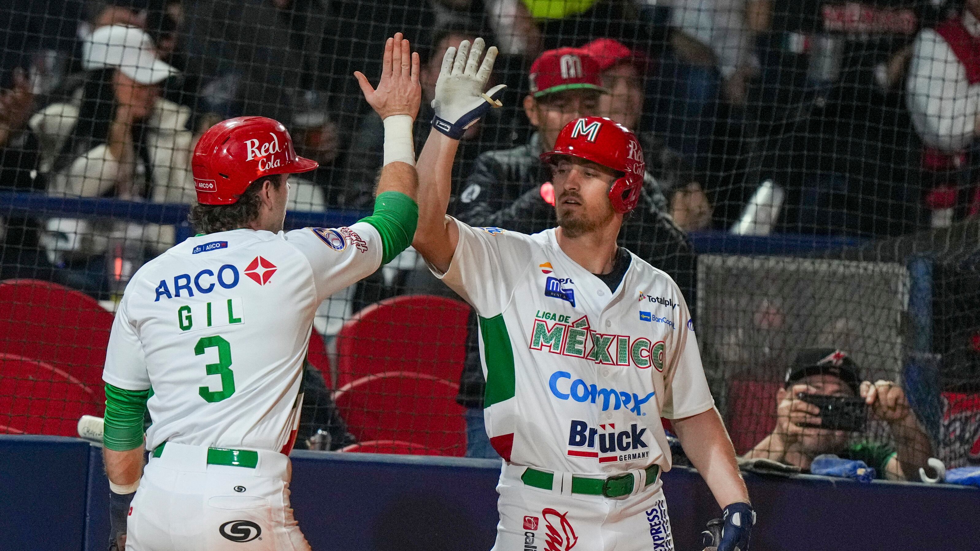 Mateo Gil festeja con Donovan Casy, su compañero de los Charros de Jalisco, tras anotar ante los Indios de Mayagüez en un juego de la Serie del Caribe disputado el viernes 31 de enero de 2025 en Mexicali (AP Foto/Fernando Llano)