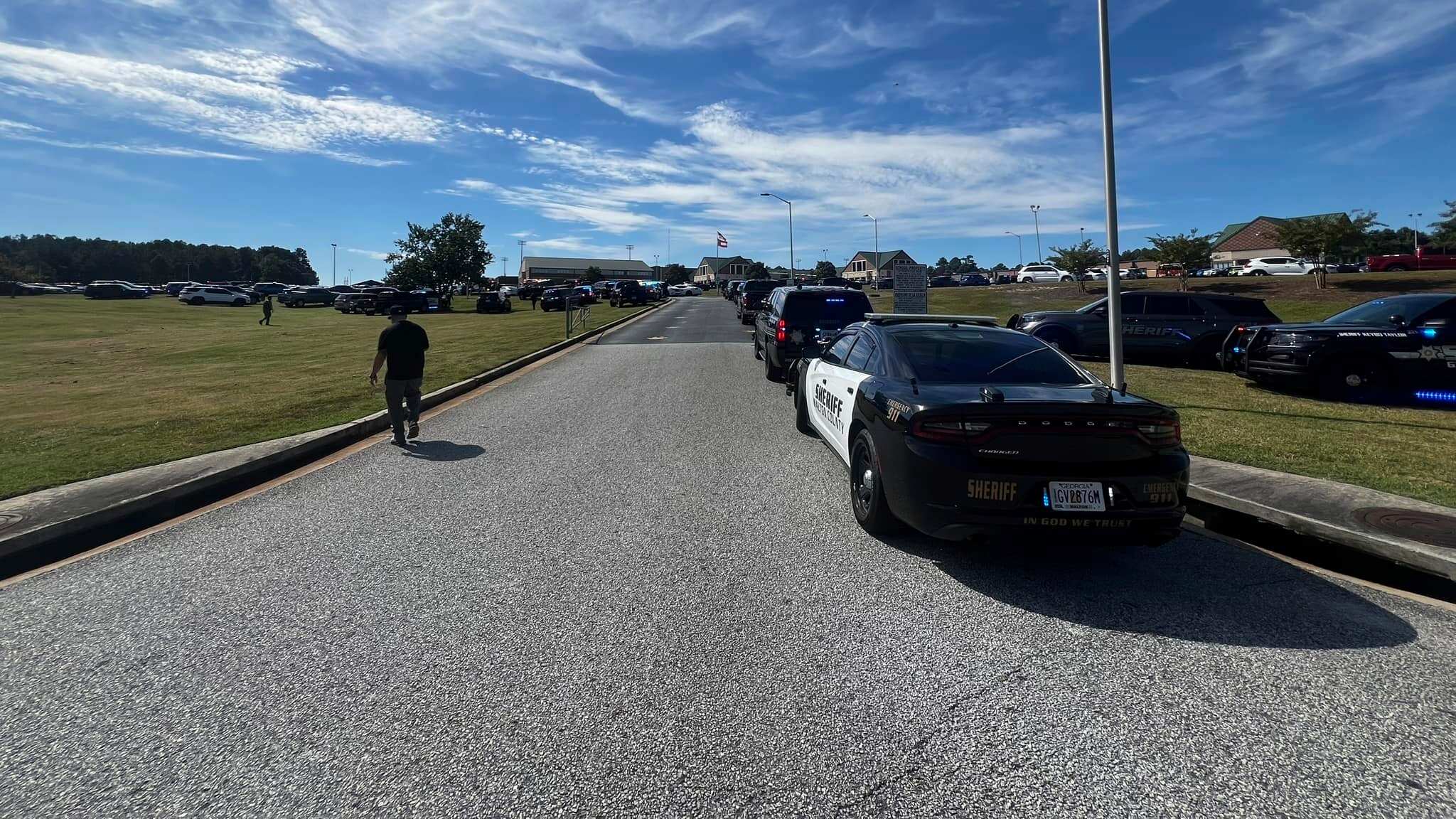 Law enforcement arrive as students are evacuated to the football stadium after the school campus was placed on lockdown at Apalachee High School in Winder, Ga., on Wednesday, Sept. 4, 2024. (Erin Clark via AP)