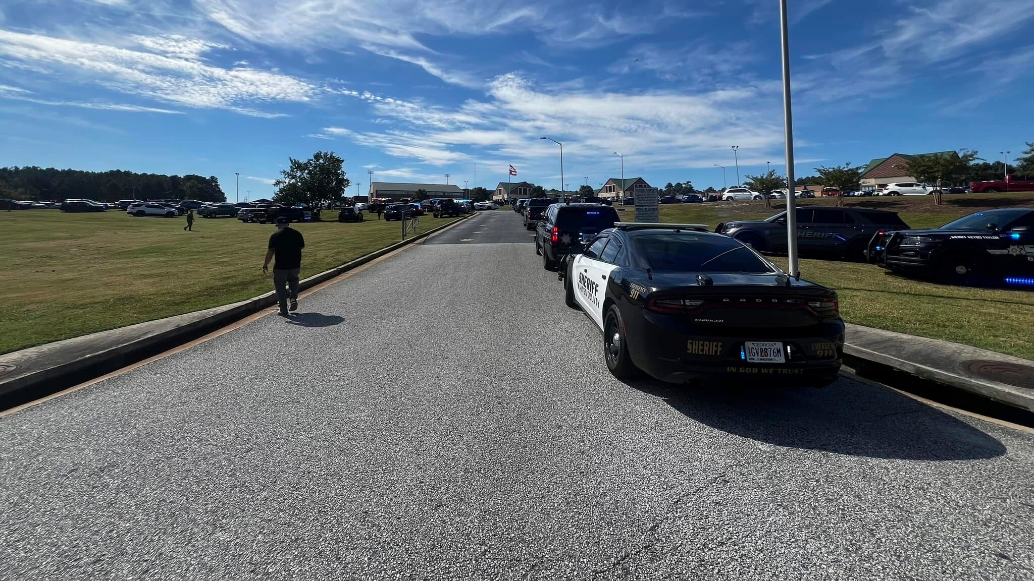 Law enforcement arrive as students are evacuated to the football stadium after the school campus was placed on lockdown at Apalachee High School in Winder, Ga., on Wednesday, Sept. 4, 2024. (Erin Clark via AP)