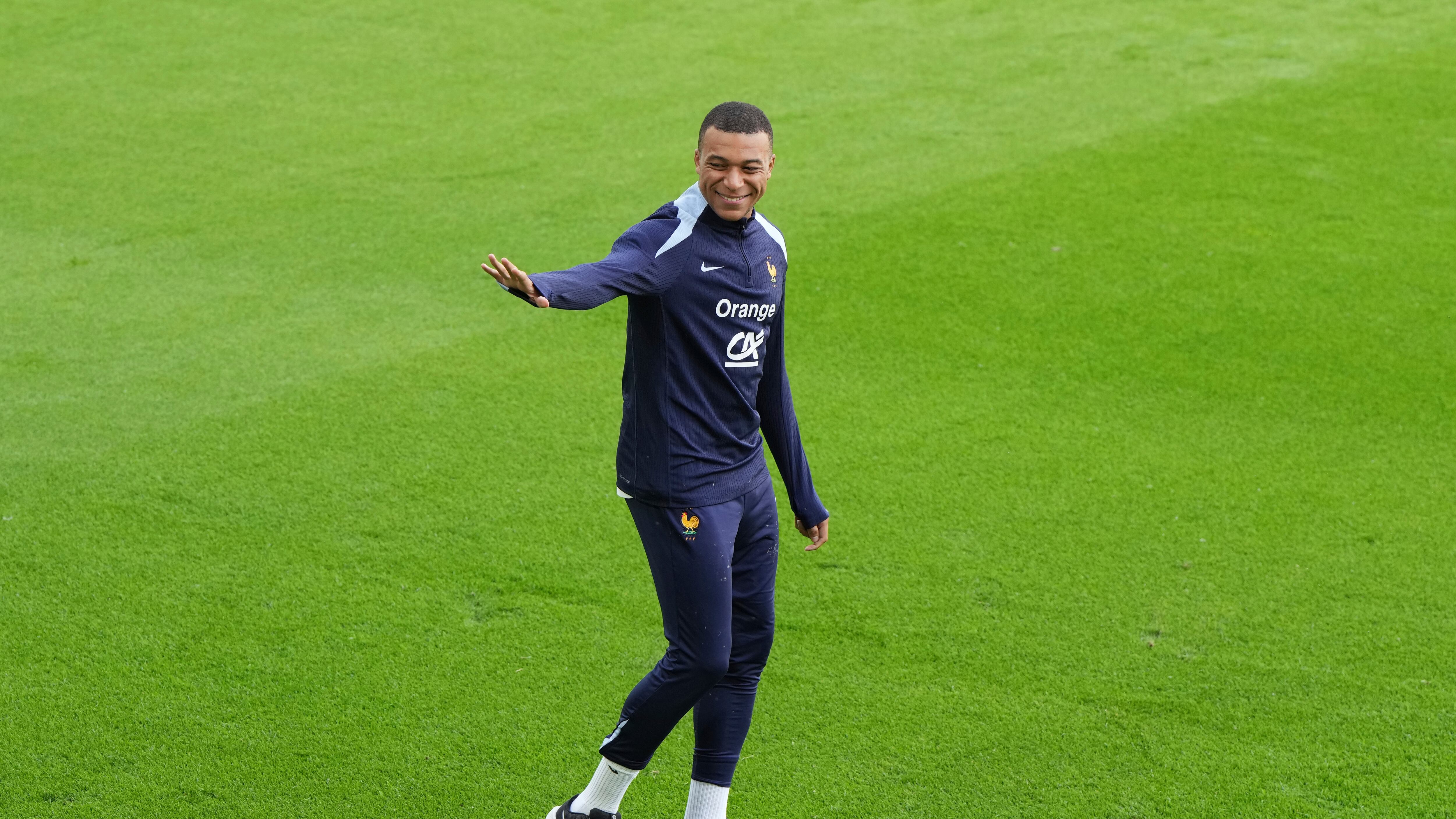 El delantero francés Kylian Mbappé saluda a los aficionados durante una sesión de entrenamientos en Paderborn, Alemania, el jueves 13 de junio de 2024. (AP Foto/Hassan Ammar)