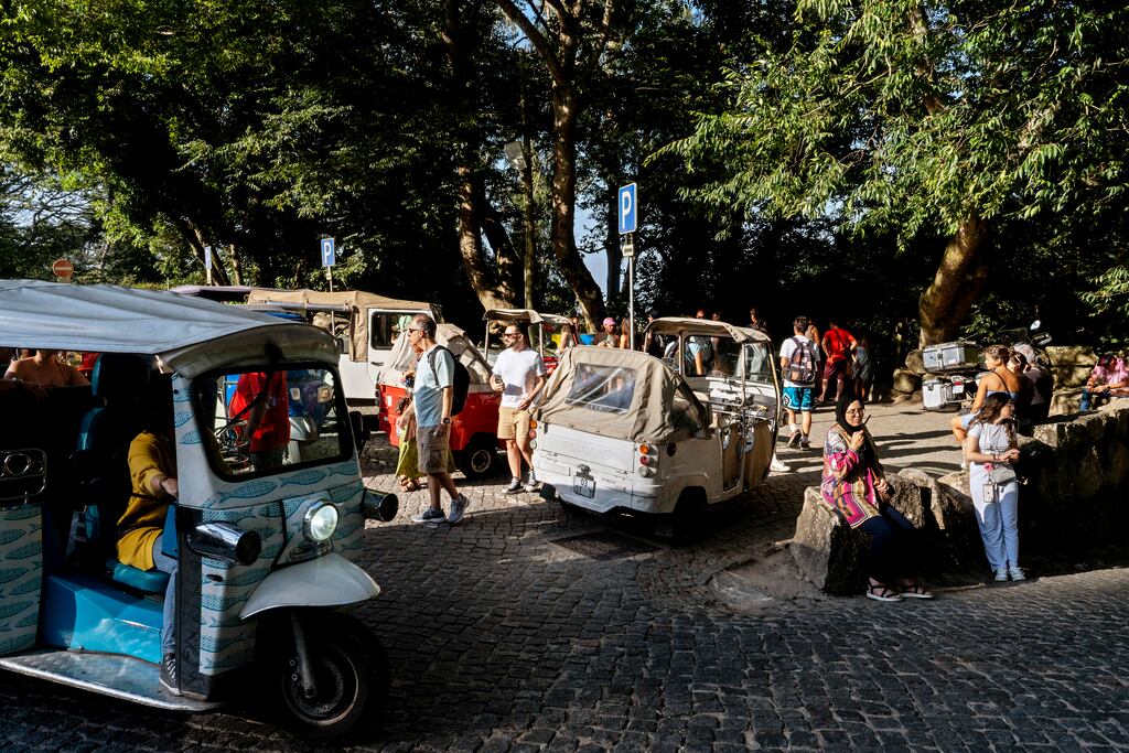Tuk-tuks dejan y recogen turistas en la entrada del Palacio Pena en Sintra, Portugal. (AP Photo/Ana Brigida)