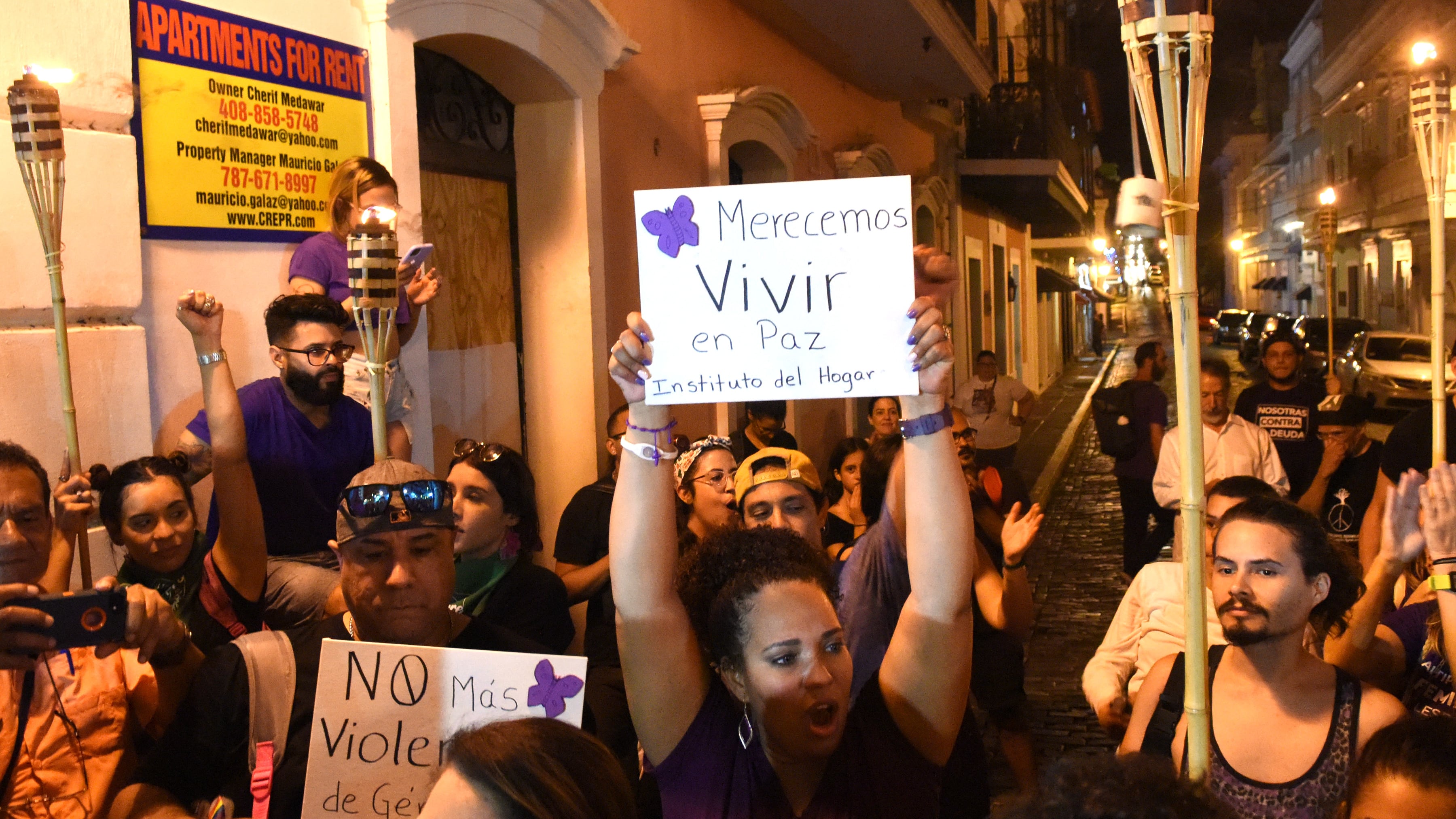 En una protesta, una mujer sostiene una pancarta que lee "merecemos vivir en paz".