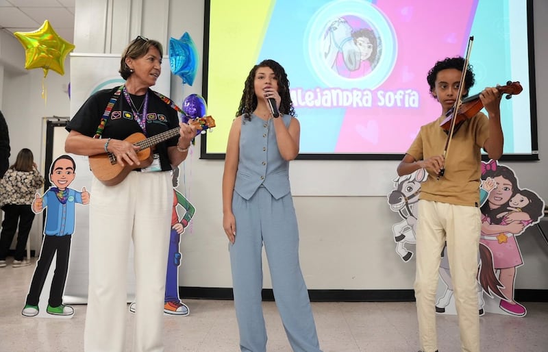 Niños interpretan canción frente a pantalla en el Hospital Pediátrico Universitario.