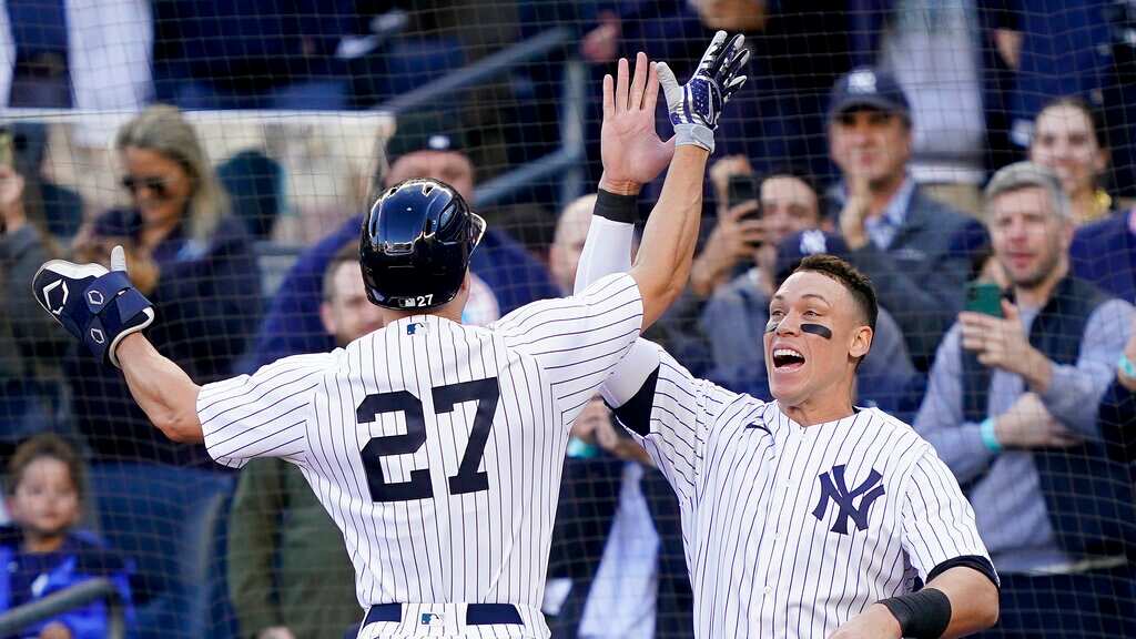 Giancarlo Stanton (27) de los Yanquis de Nueva York celebra con Aaron Judge tras conectar un jonrón solitario ante los Guardianes de Cleveland en el quinto juego de la serie divisional de la Liga Americana, el martes 18 de octubre de 2022. (AP Foto/John Minchillo)